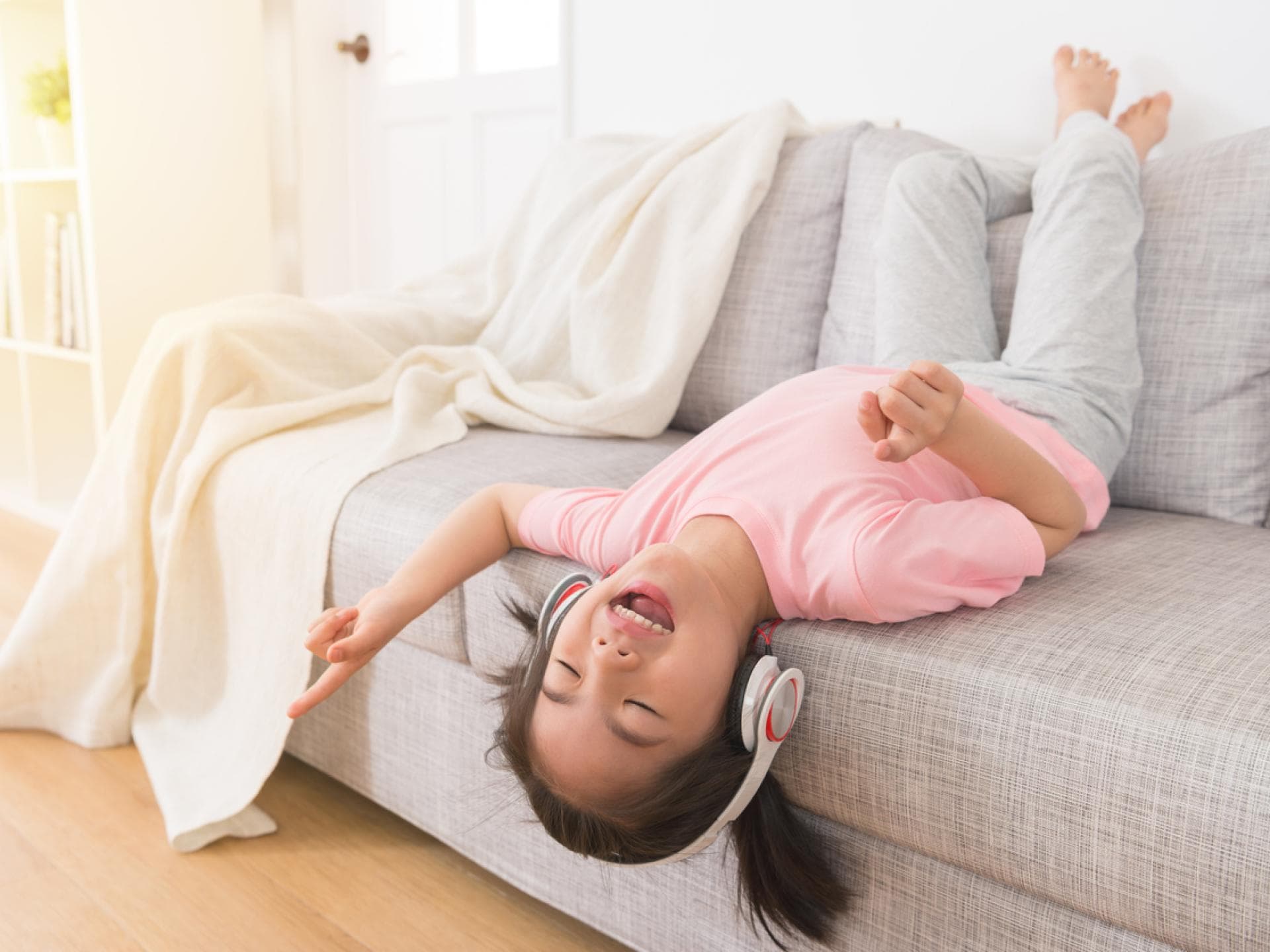 4-Jährige hört Musik mit Kopfhörern.