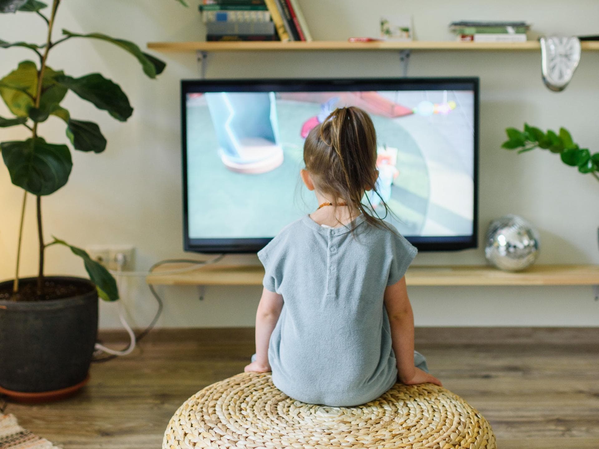 Ein kleines Mädchen guckt Fernsehen. 