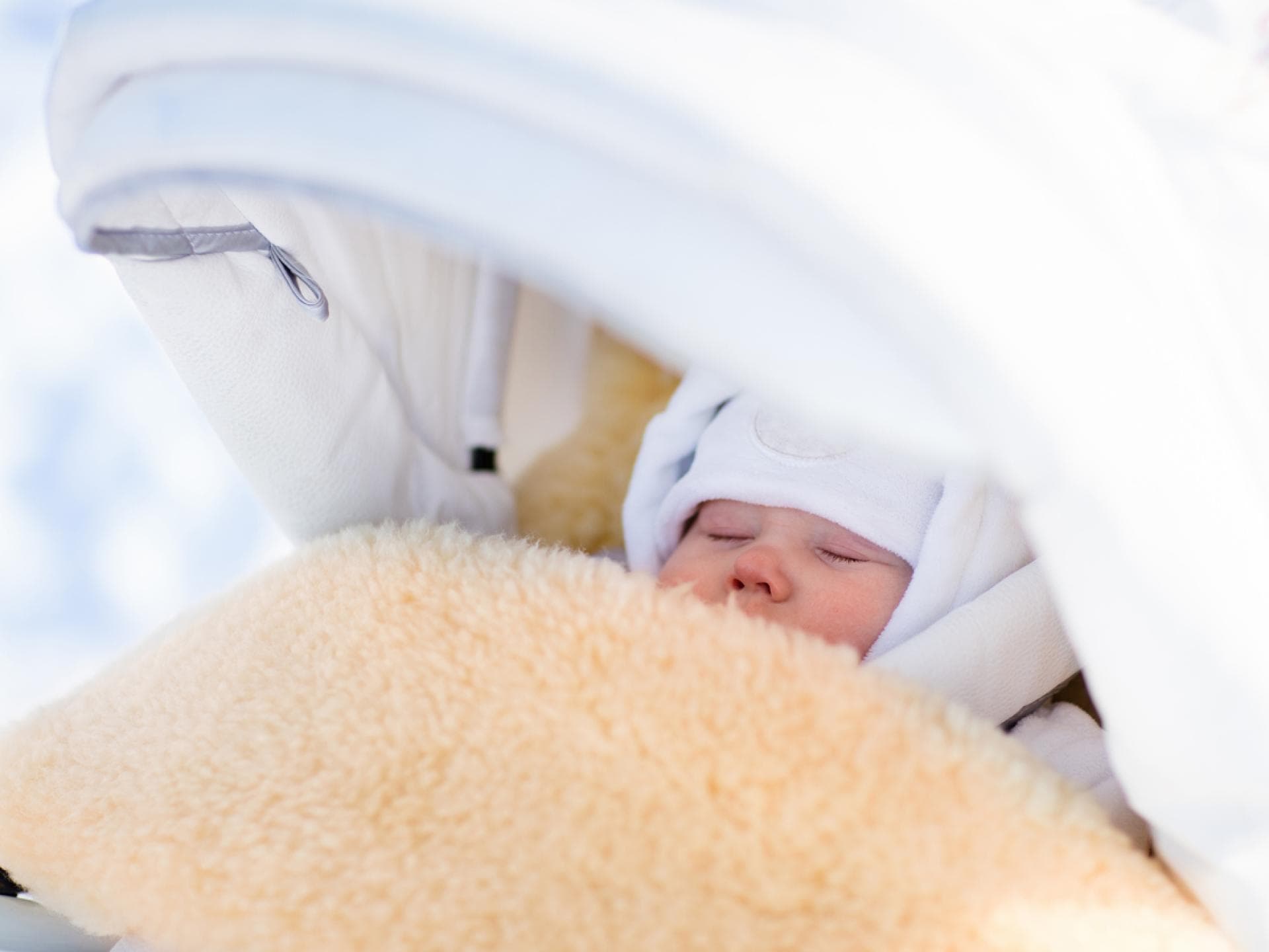 Baby schläft im Winter draußen im Kinderwagen.