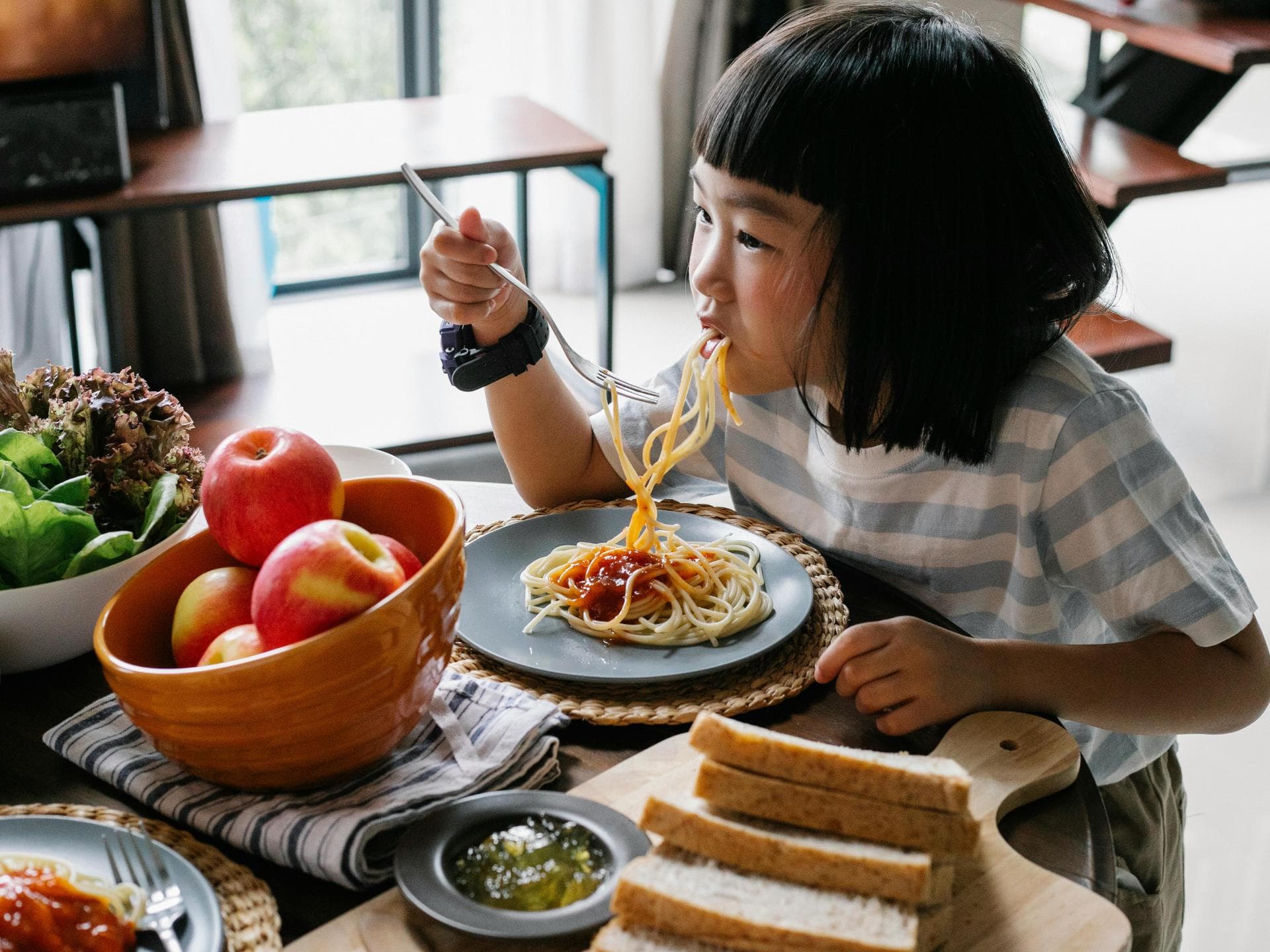 Mädchen isst Spaghetti.