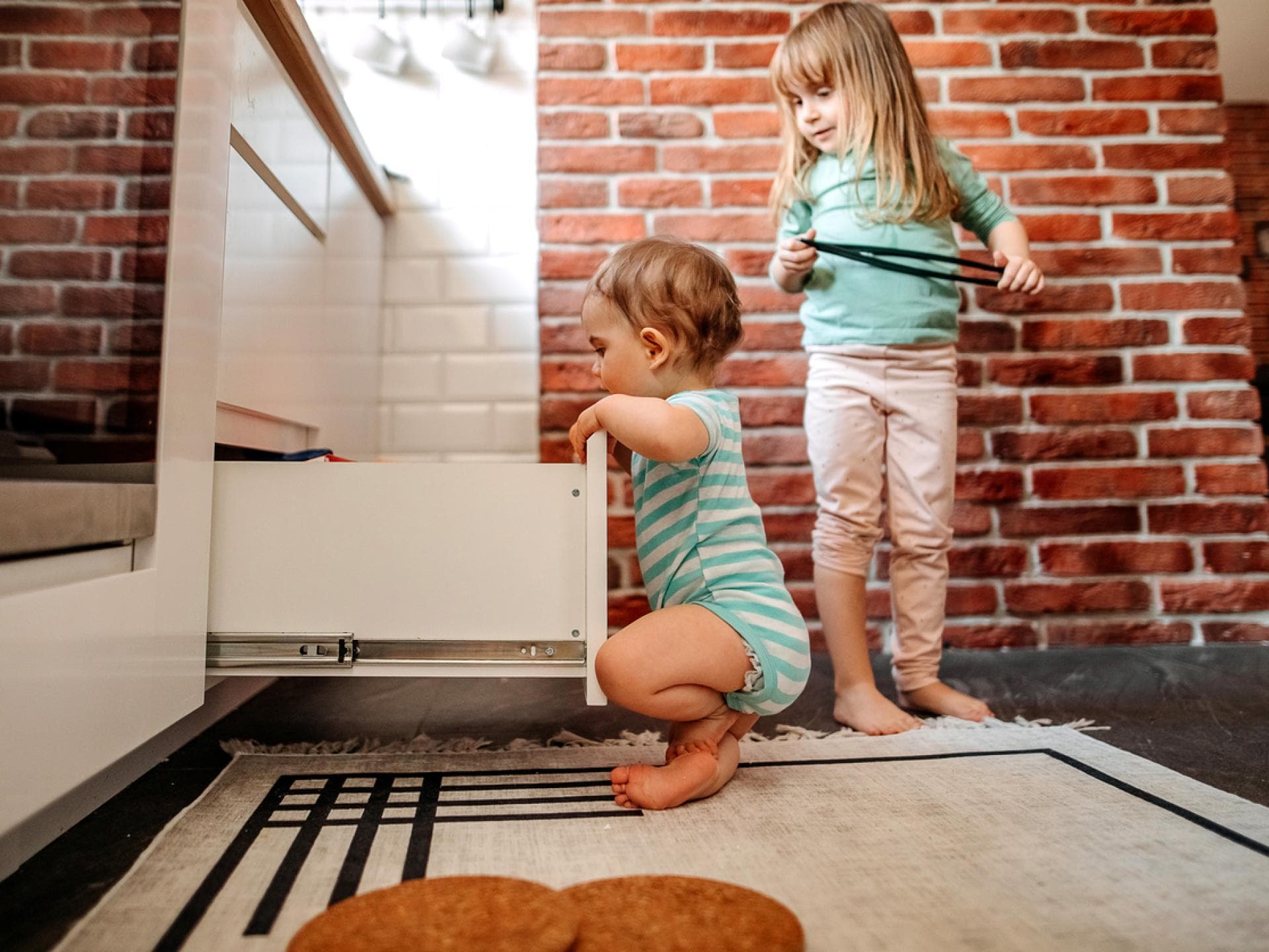 Zwei kleine Kinder schauen nach Süßigkeiten in der Ja-Schublade. Zwei kleine Kinder schauen nach Süßigkeiten in der Ja-Schublade.