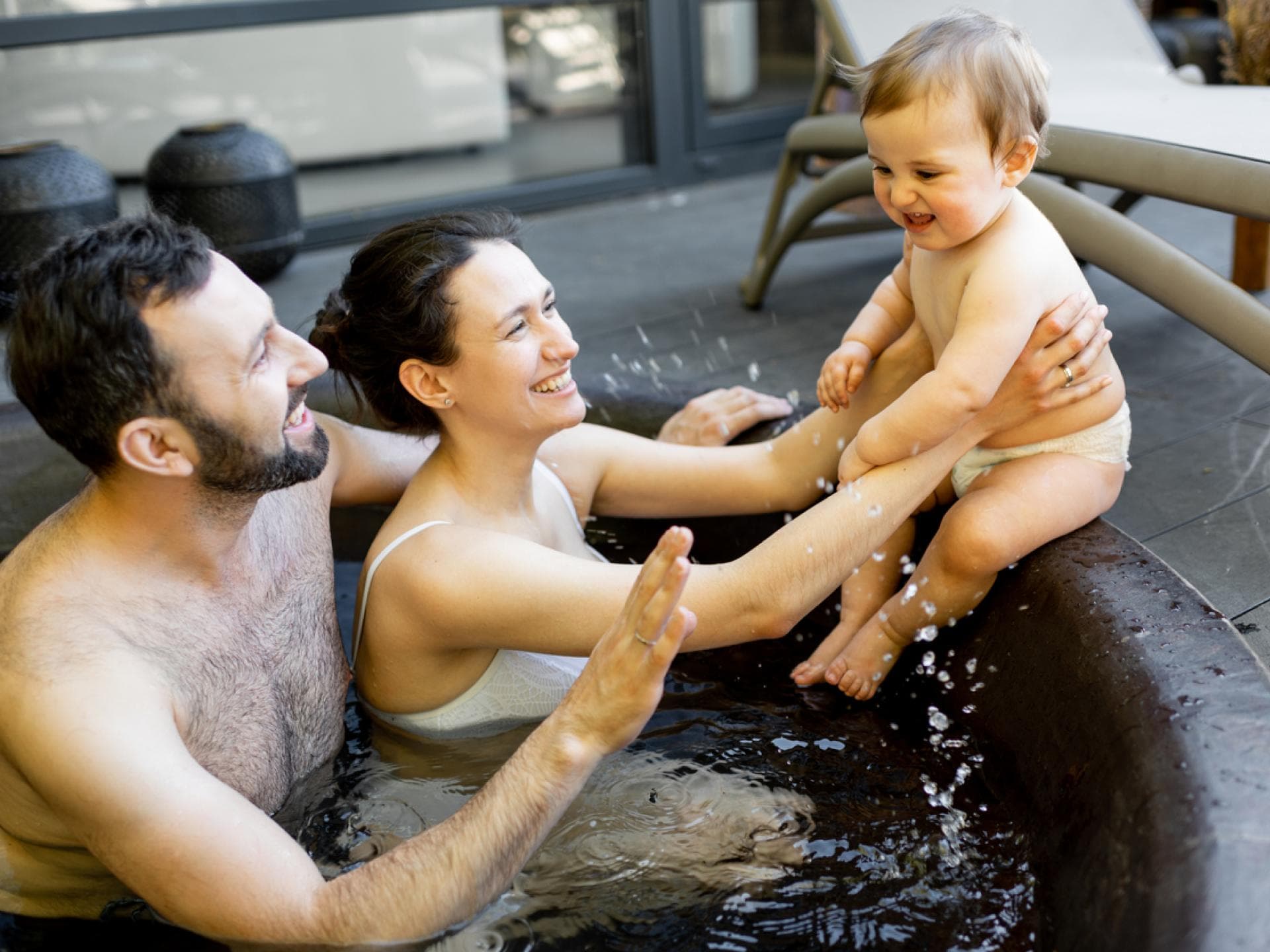 Eltern mit Baby im Pool