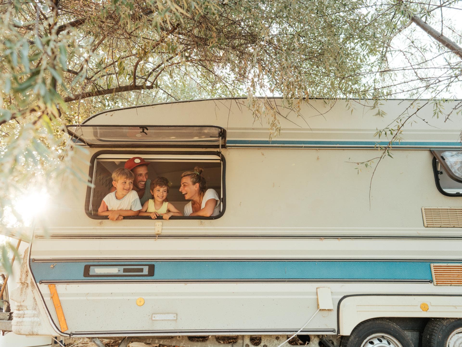 Familie schaut aus Wohnmobil-Fenster