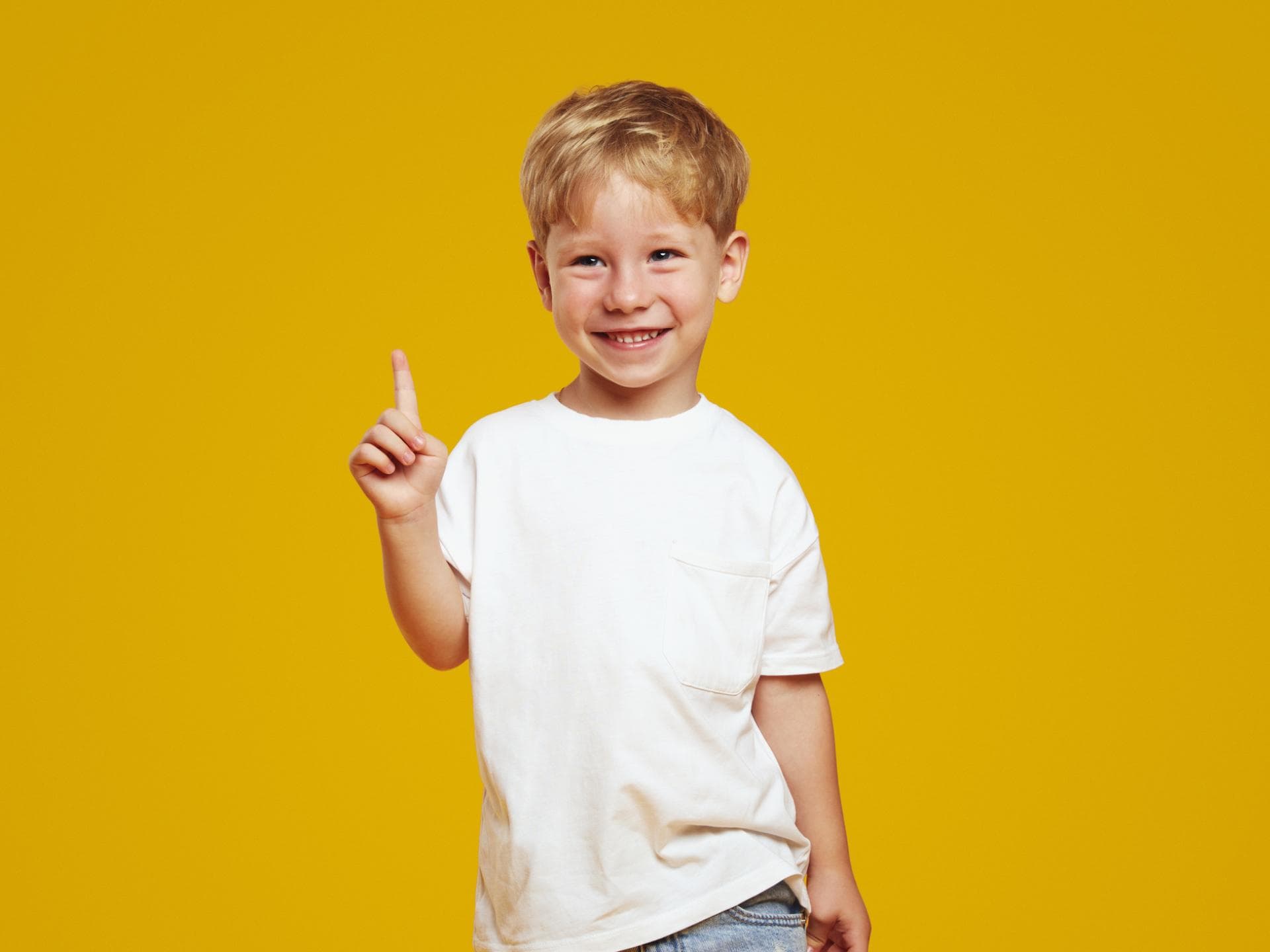 Ein kleiner Junge hebt seinen Zeigefinger