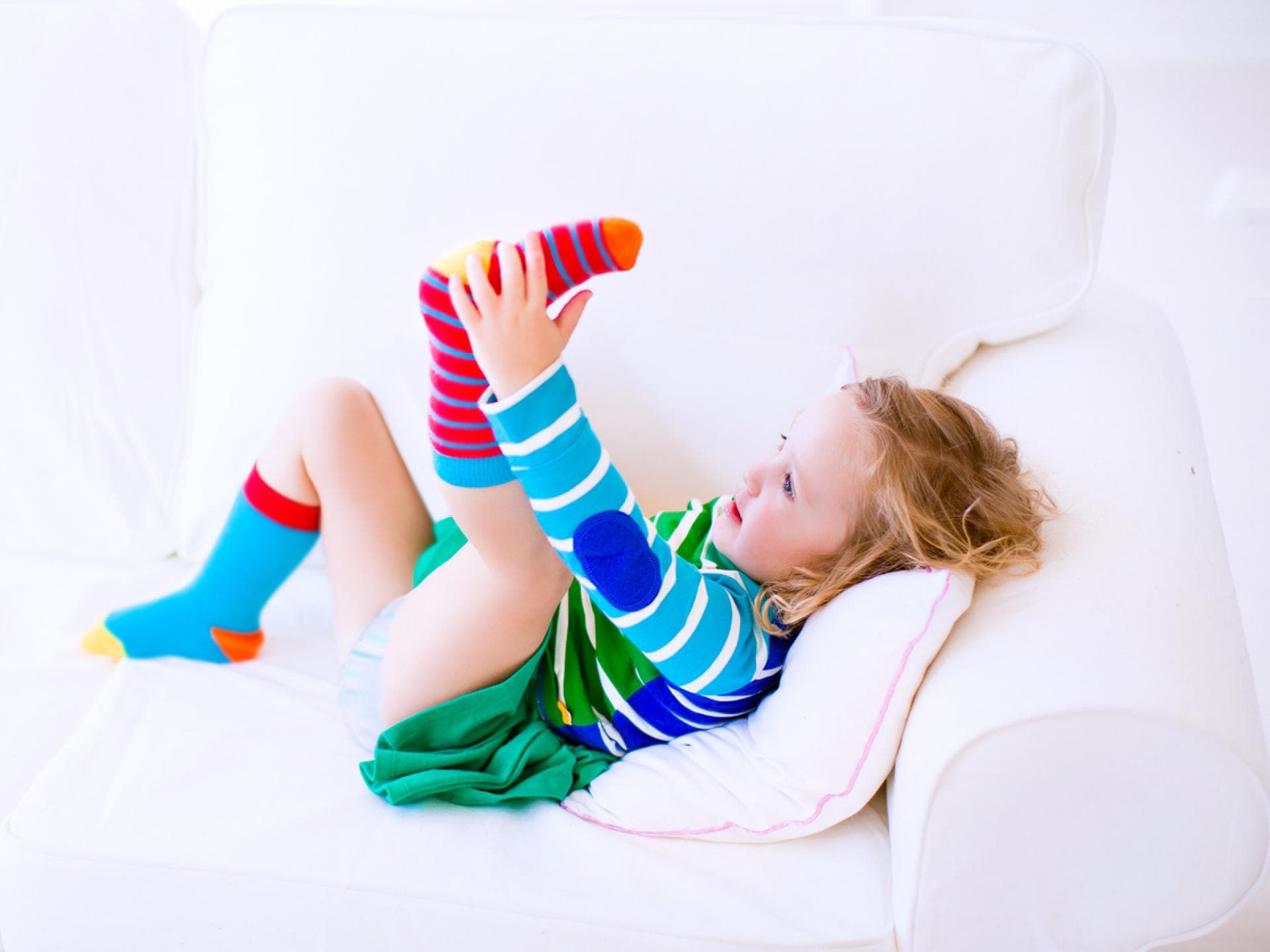 Hilfe beim Socken anziehen braucht dieses Mädchen mit ihren bunten Strümpfen nicht mehr. Hilfe beim Socken anziehen braucht dieses Mädchen mit ihren bunten Strümpfen nicht mehr.