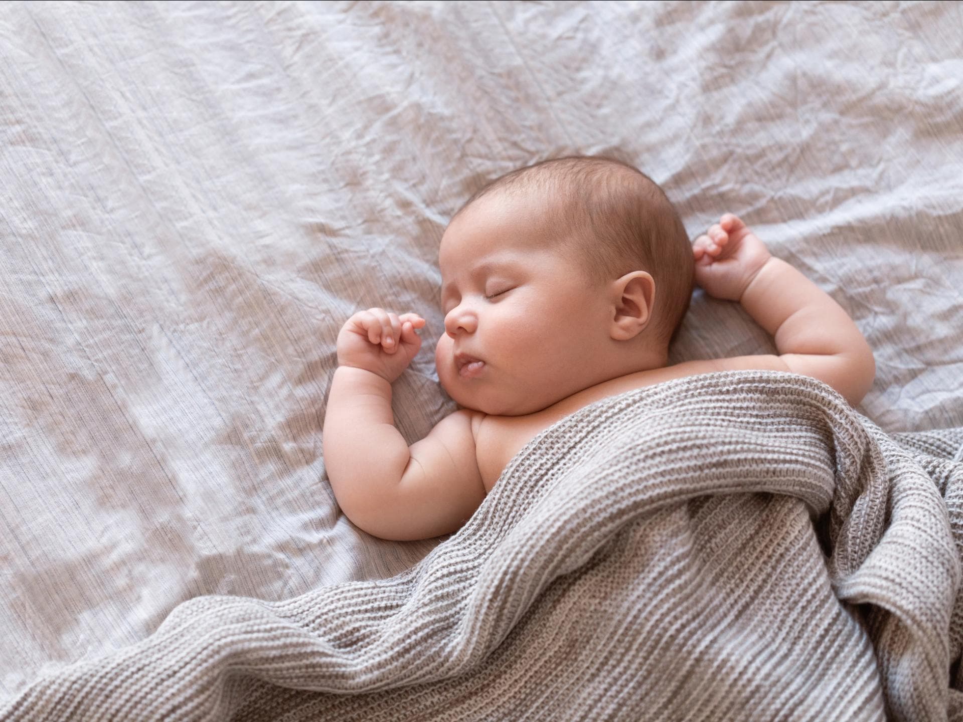 Den Schlaf von Babys kann man positiv beeinflussen. Ein schlafendes Baby ist abgebildet.