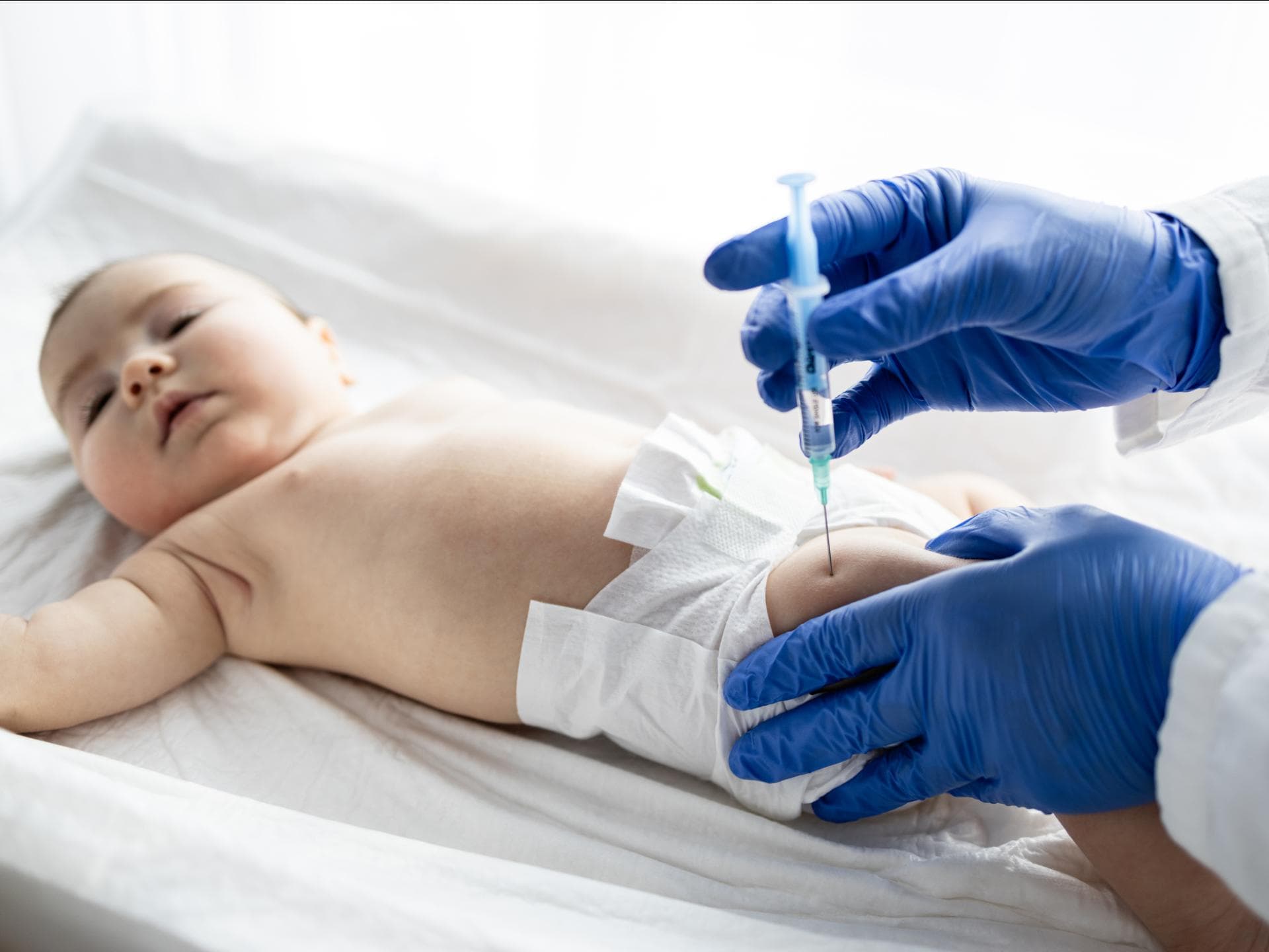Ein Baby wird in den Oberschenkel geimpft.