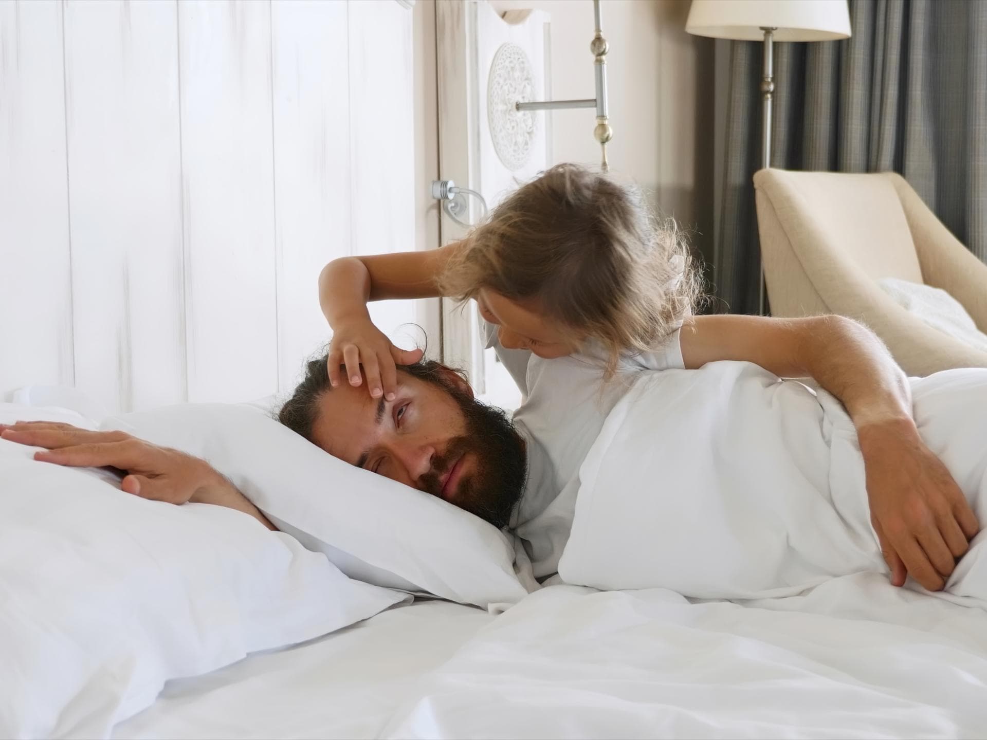 Wie gerne würden wir manchmal einfach noch länger schlafen?! Mädchen öffnet dem Papa die Augen.