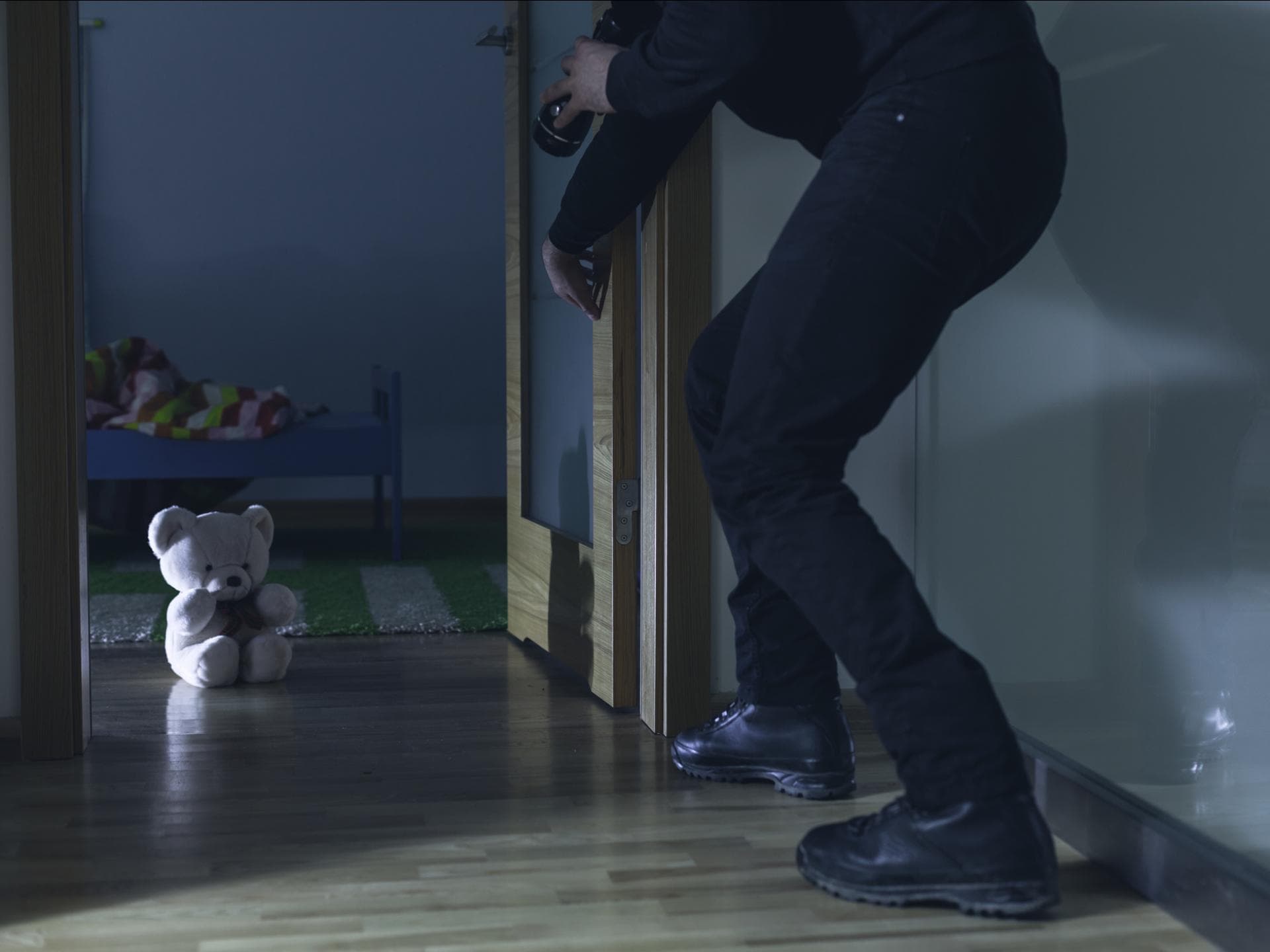 Einbrecher schleicht sich ins Kinderzimmer.