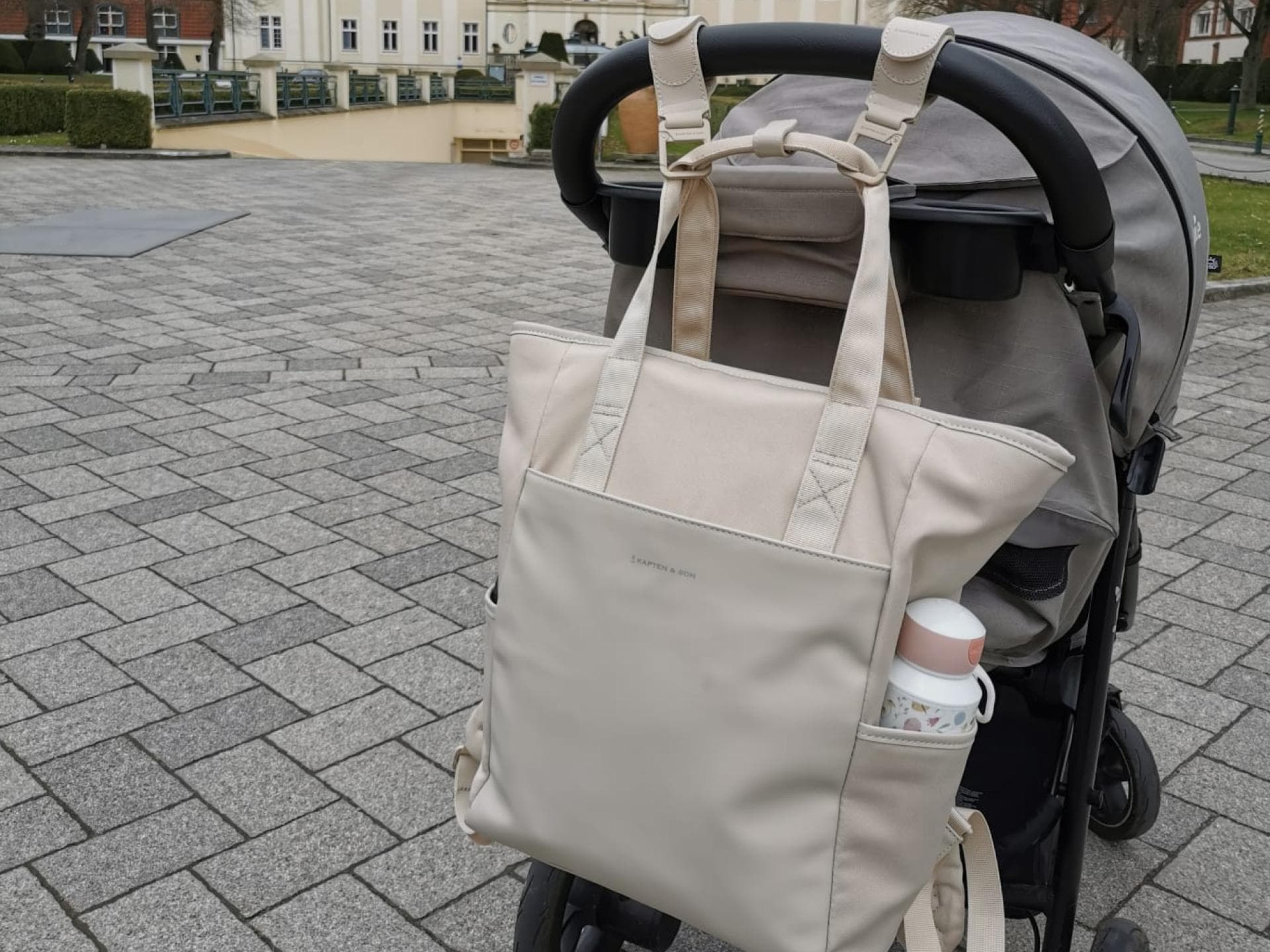 Wickelrucksäcke sind für Eltern unabdingbar. Der Wickelrucksack in Sandstone von Kapten & Son hängt am Buggy unserer Redakteurin.
