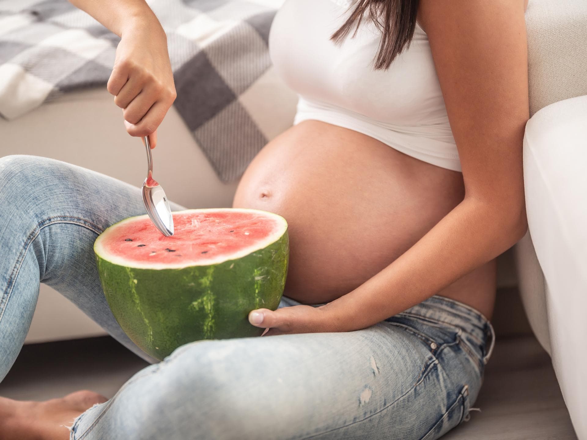 Schwangere löffelt Wassermelone.