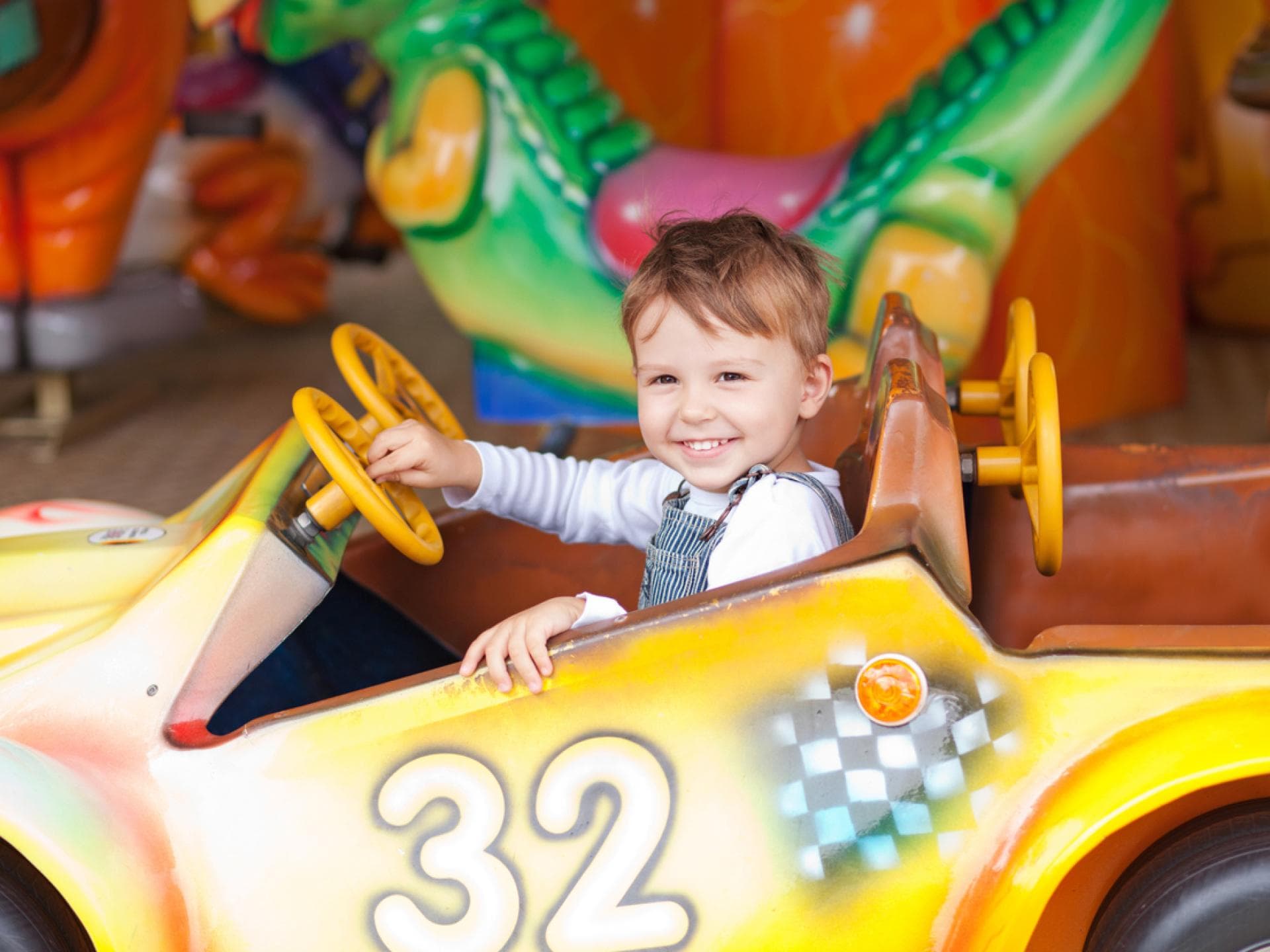 Ein kleiner Junge im Auto im Freizeitpark.