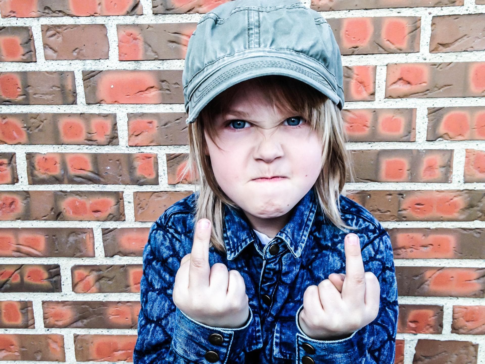 Kleines Mädchen zeigt den Mittelfinger.