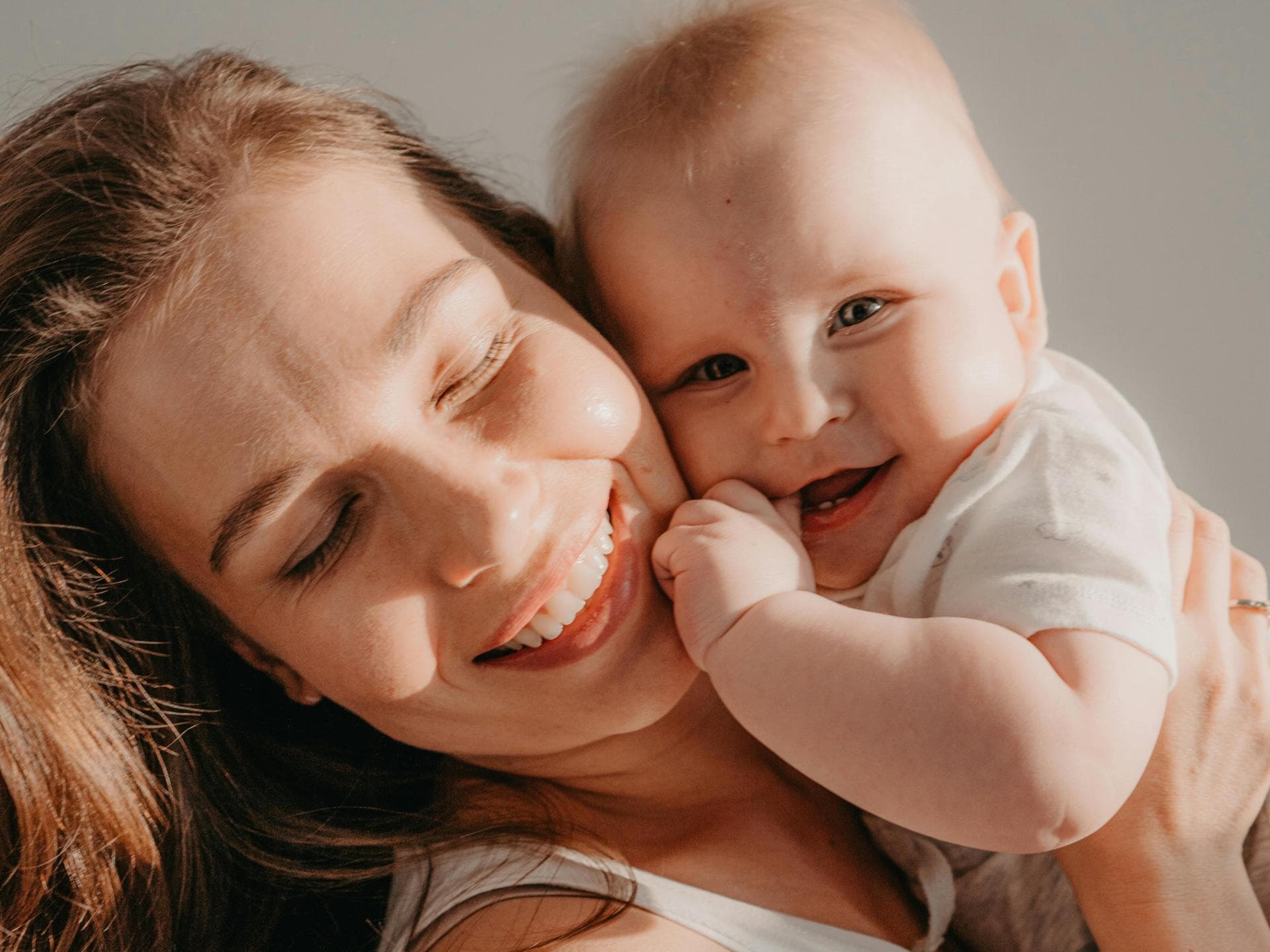 Glückliche Mutter mit süßem Baby auf dem Arm.