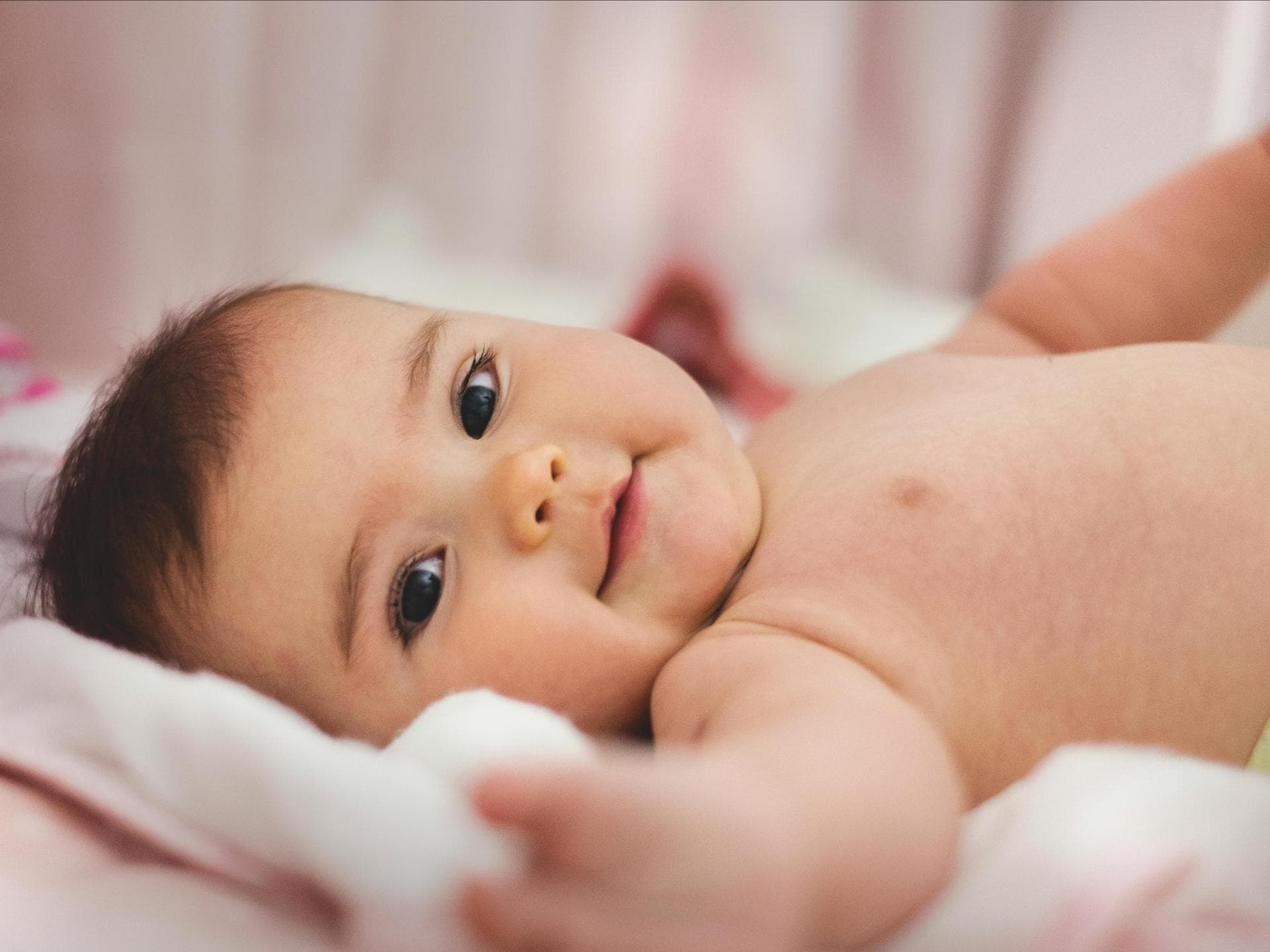 Baby lächelt in die Kamera.