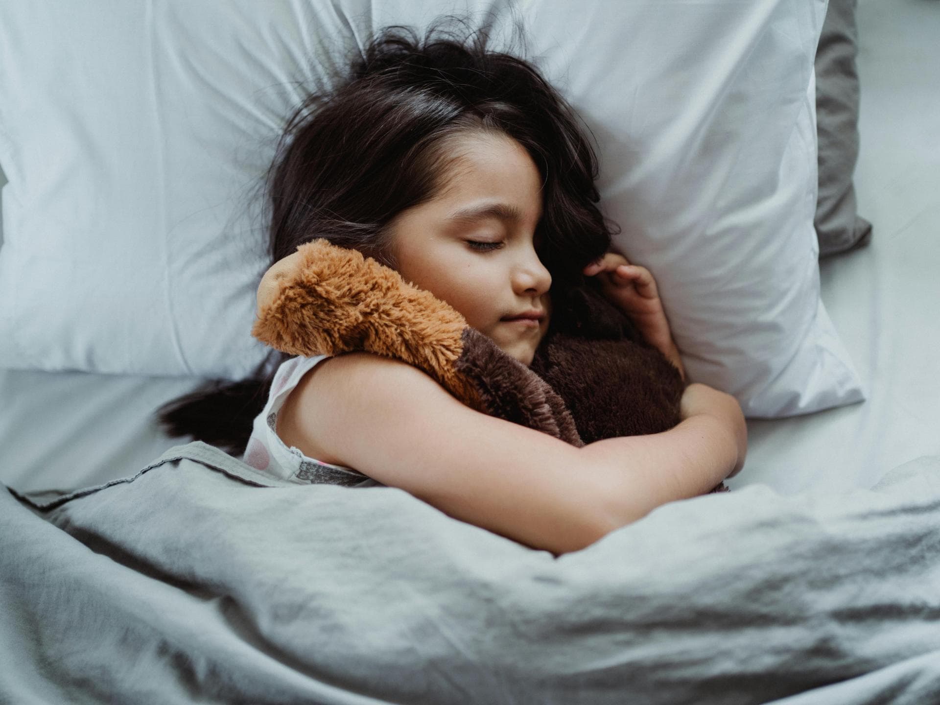Bestimmte Tonies können Kindern beim Einschlafen helfen. Ein Mädchen liegt schlafend in ihrem Bett.