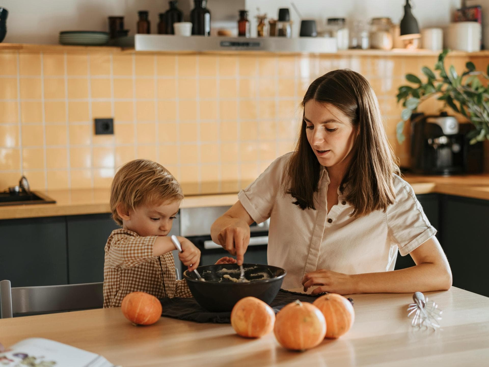 Eine Mutter kocht zusammen mit ihrem kleinen Sohn.