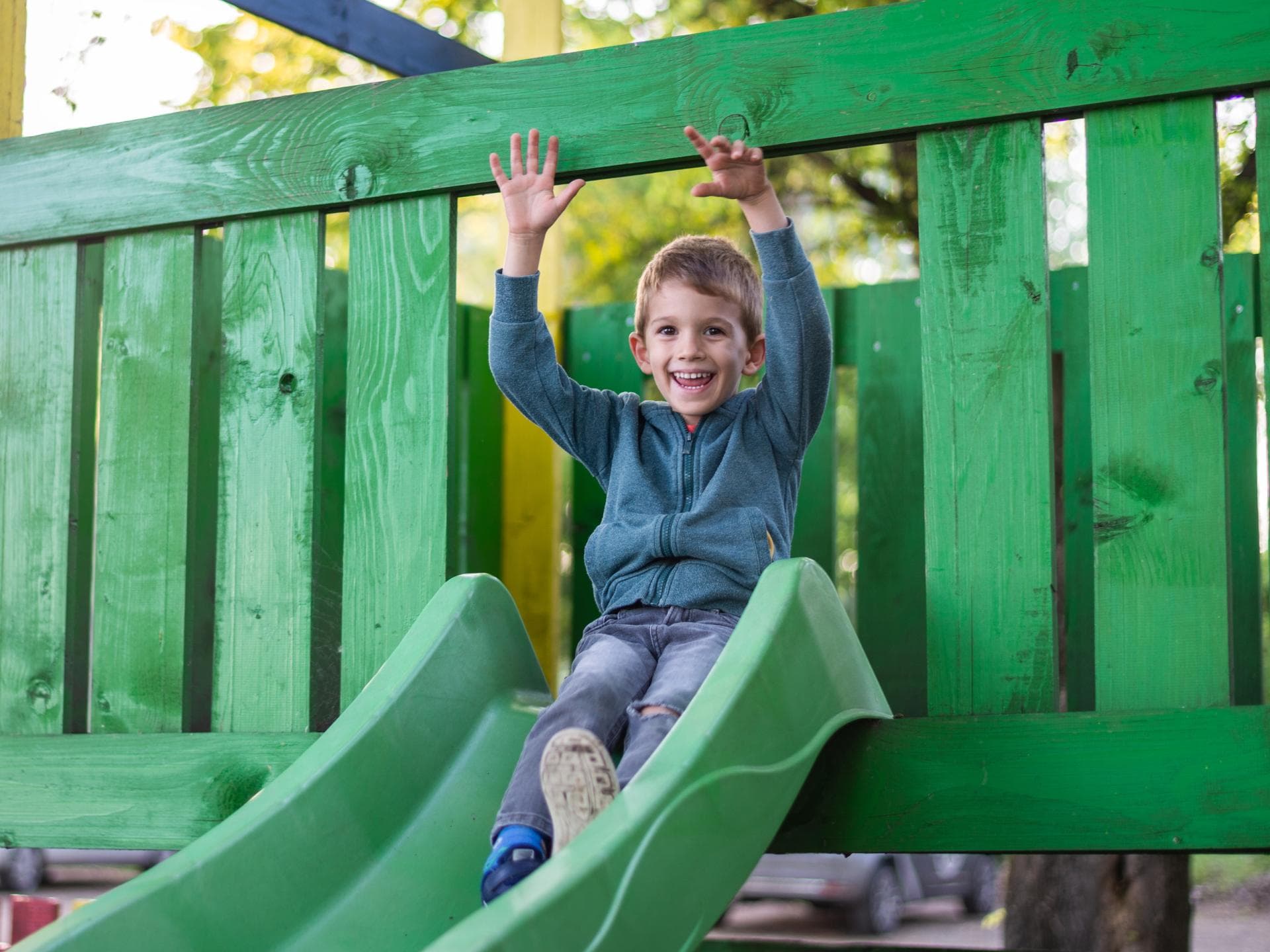 Eine Junge auf einem Klettergerüst am Spielplatz. 