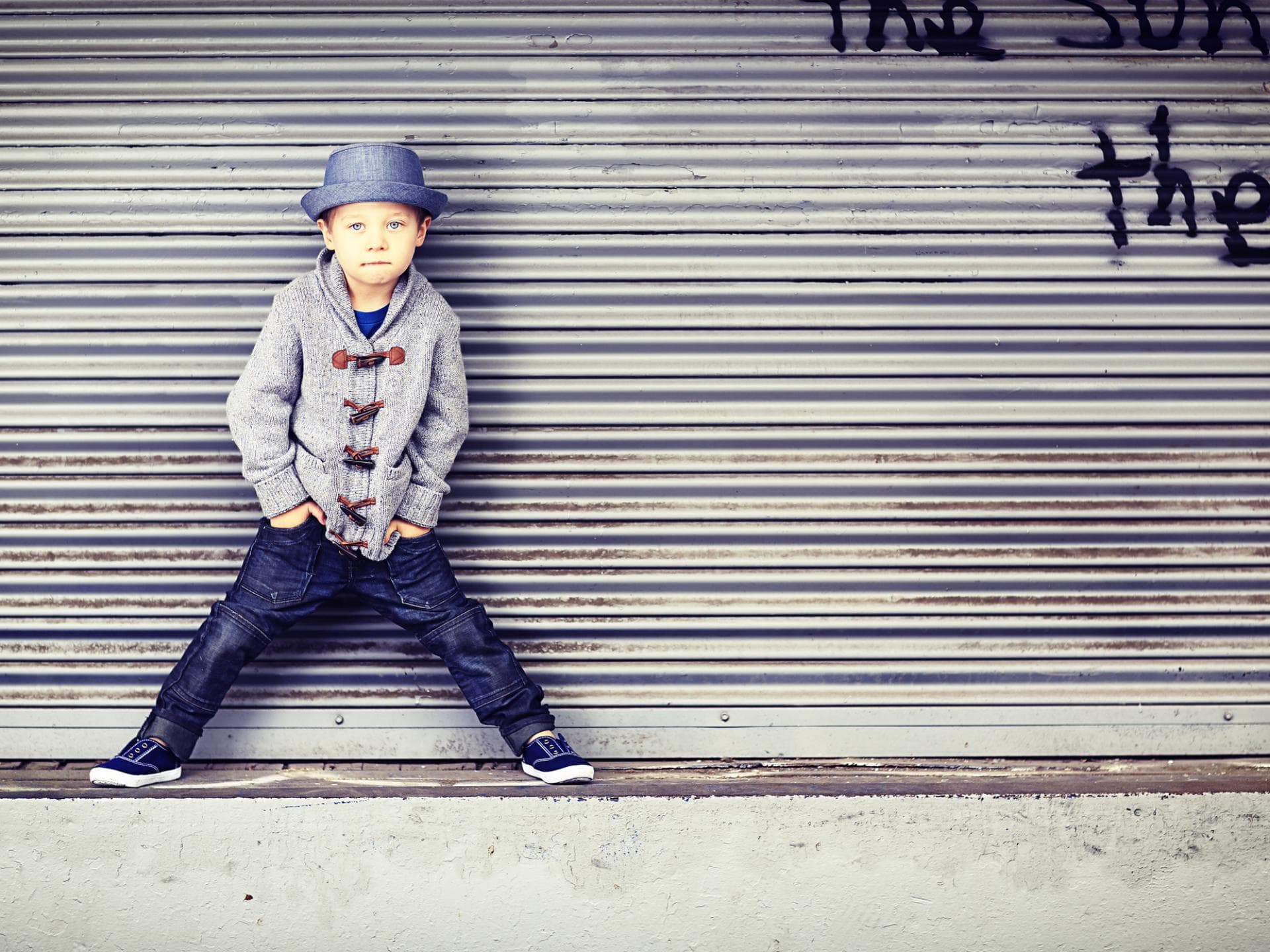 Kleiner Junge in mit Hut posiert cool.