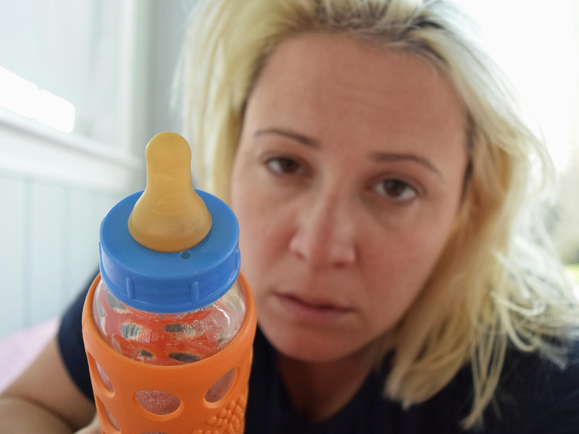 Schlafmangel bei Müttern Eine Mutter, die eine Flasche in der Hand hält ...