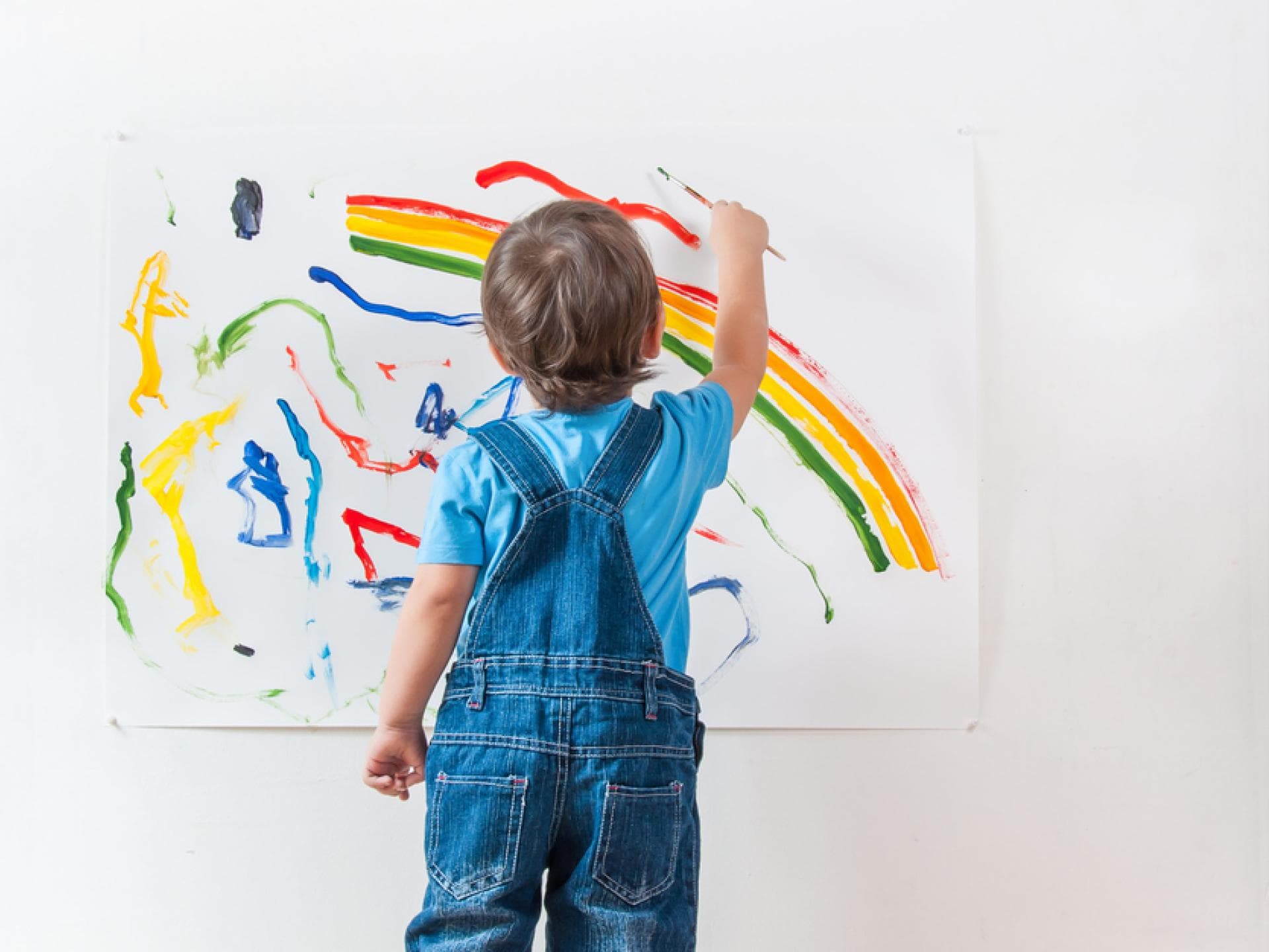 Die Kunst eines Zweijährigen wird weltweit gefeiert. Kleiner Junge malt mit Pinsel.