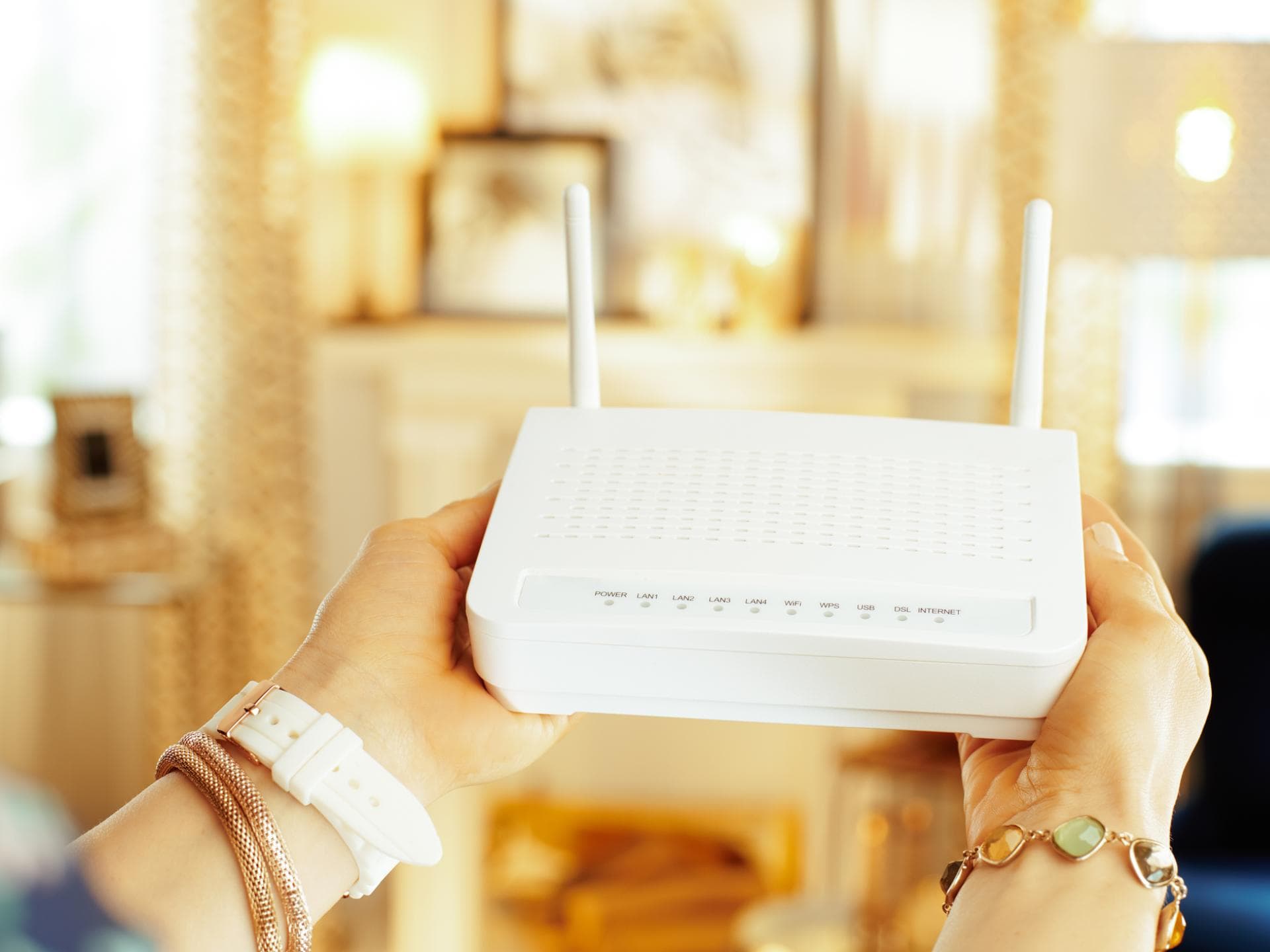 Frau hält einen WLAN-Router in der Hand.