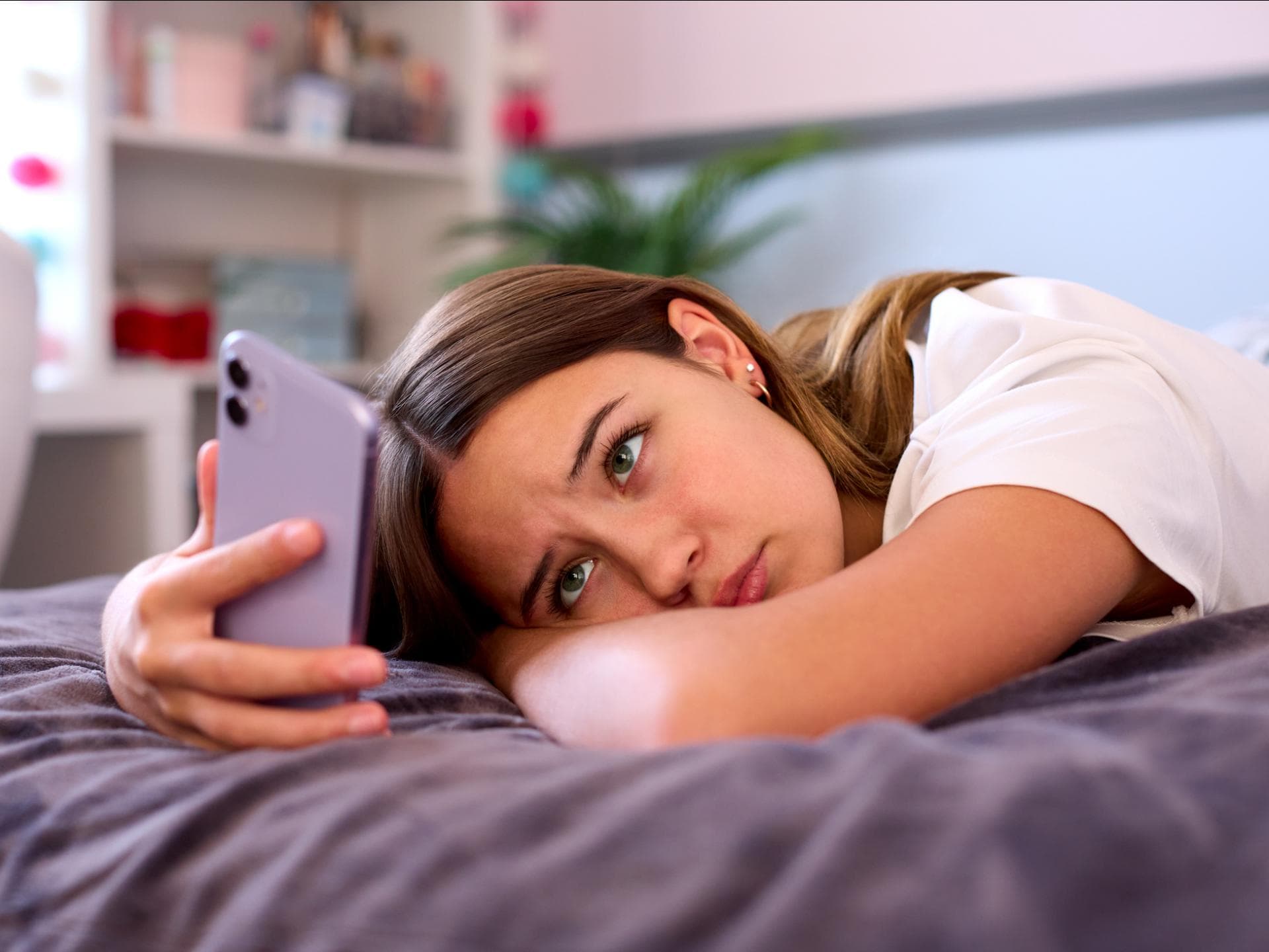 Sadfishing ist nicht ohne. Trauriges Teenager-Mädchen schaut auf ihr Smartphone.