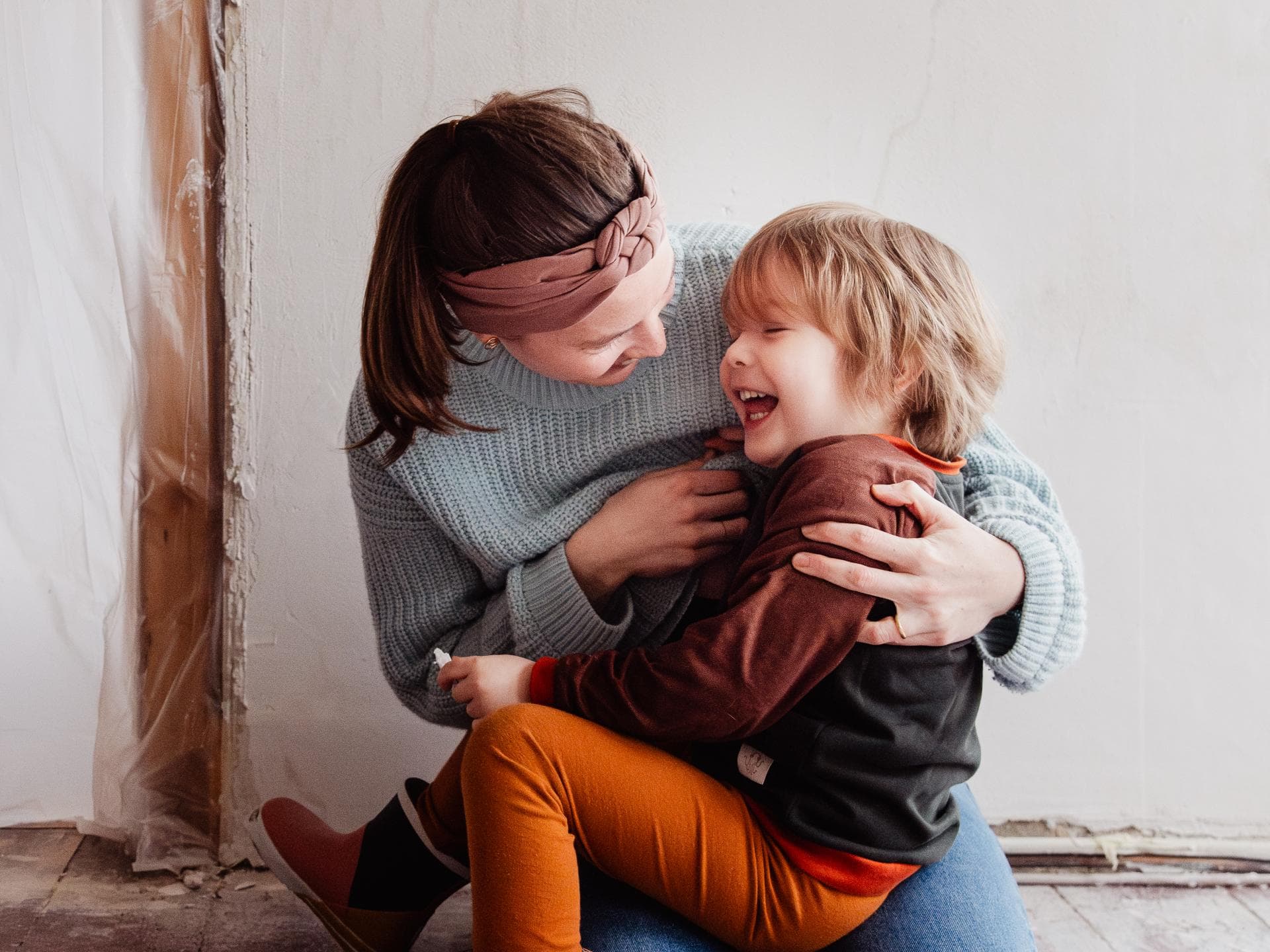 Wunderschönes Fotoprojekt übers Langzeitstillen Eine Mutter und ihr Kleinkind lachen beim Stillen