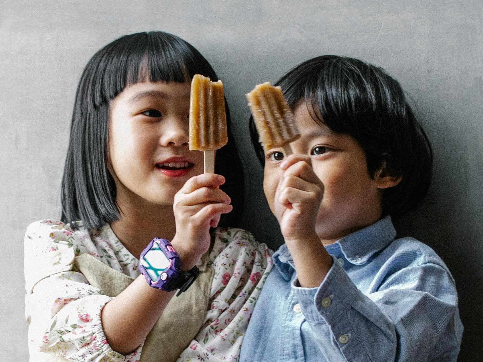 Zwei Kinder mit Fruchteis in der Hand.