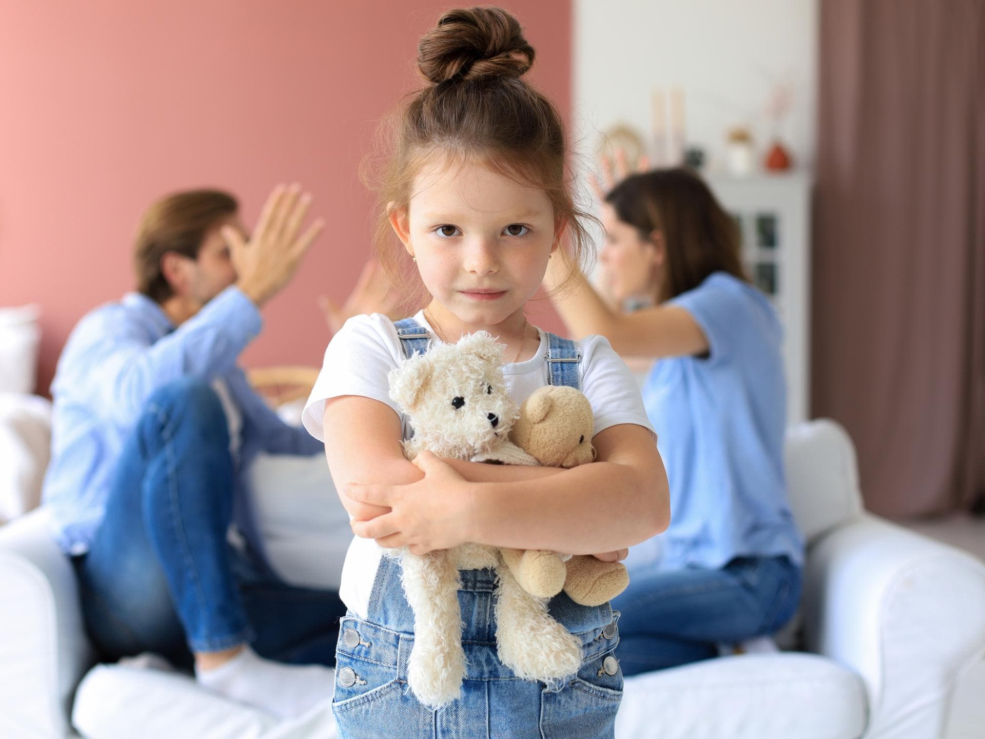 Kinder lernen die Streitkultur von ihren Eltern. Eltern streiten, Mädchen umarmt ihr Kuscheltier.