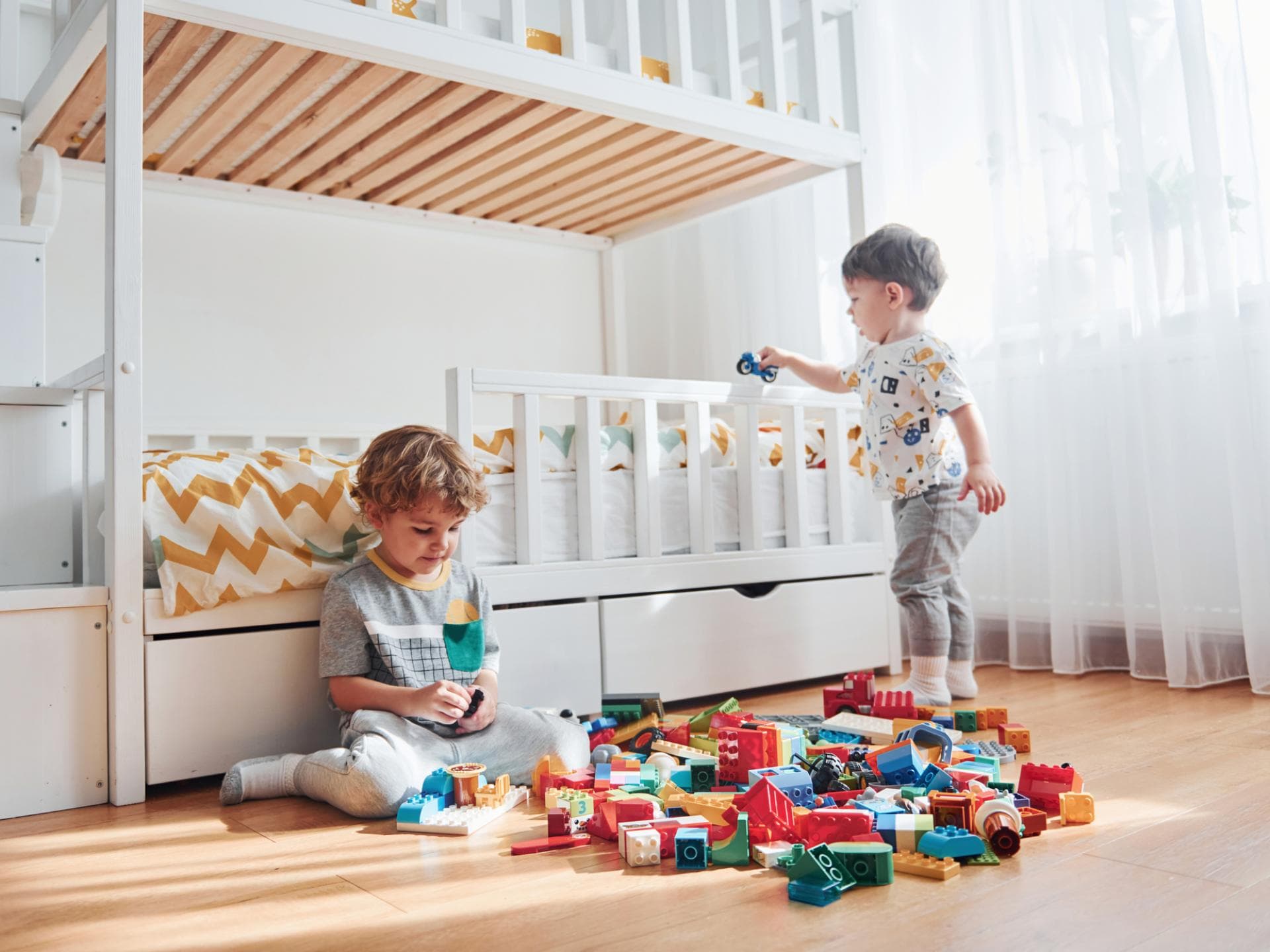 Zwei Jungs spielen neben ihrem Hochbett.