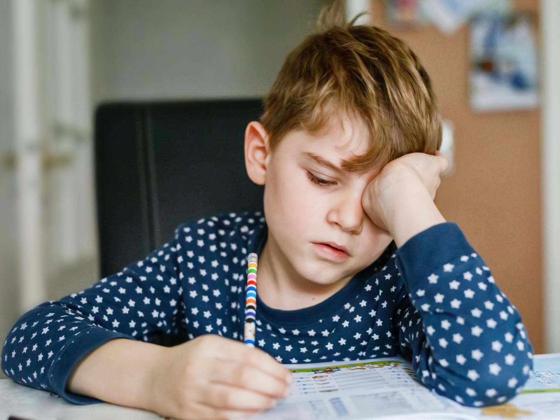 Ist es sinnvoll, wenn Kinder auch in den Ferien für die Schule lernen? Ein kleiner Junge ist genervt von seinen Hausaufgaben.
