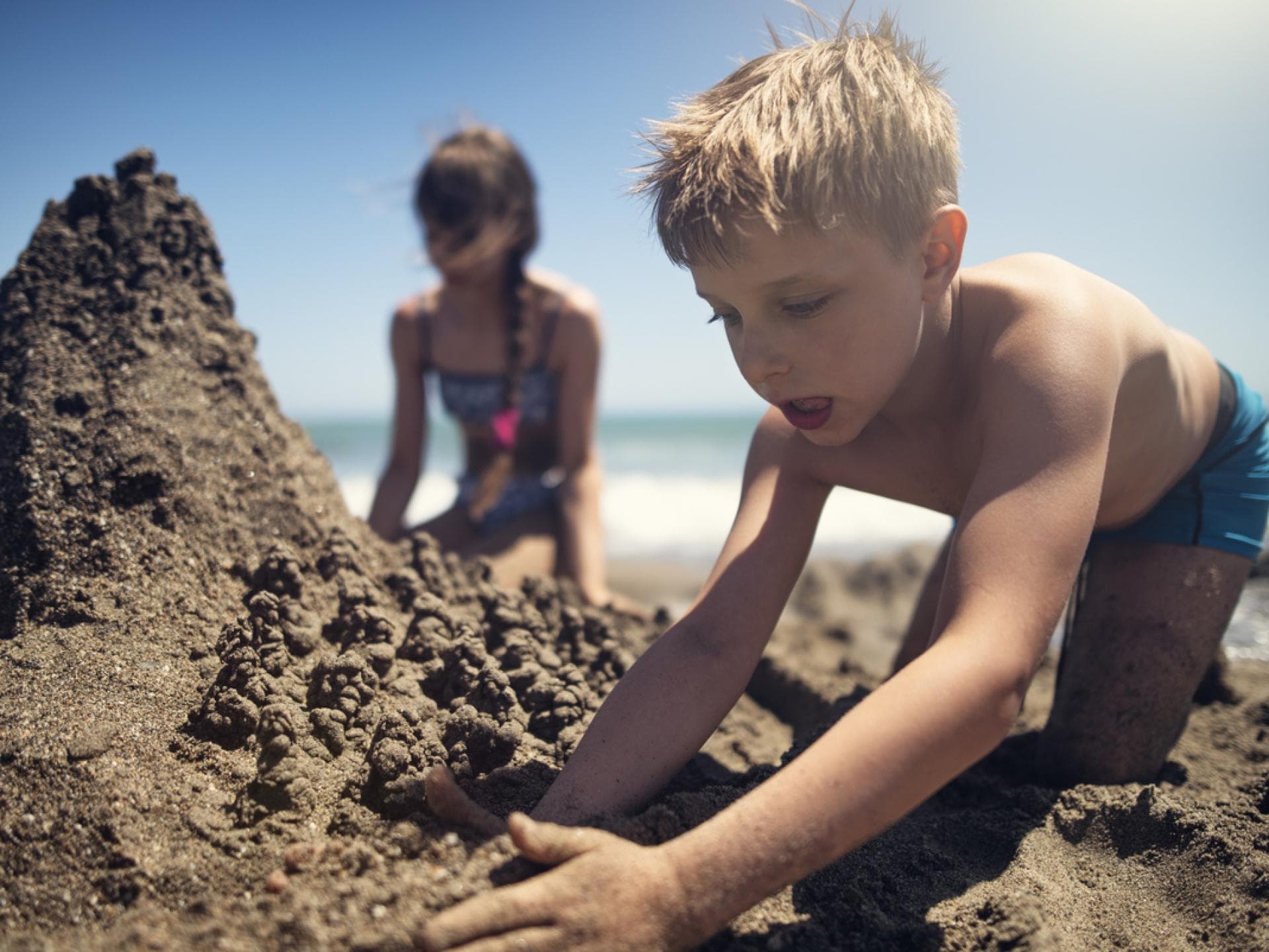 Kinder buddeln am Strand.