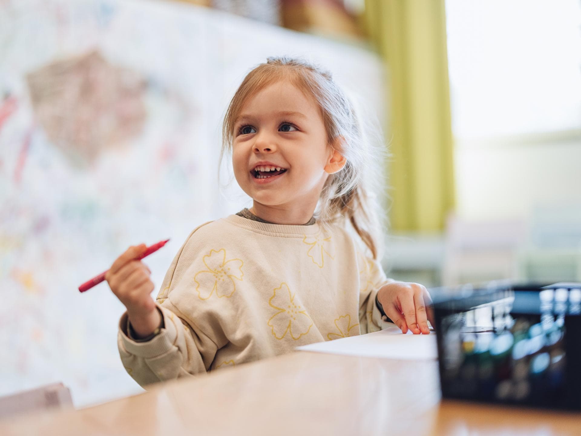 Ein kleines Mädchen mit einem Stift in der Hand. 