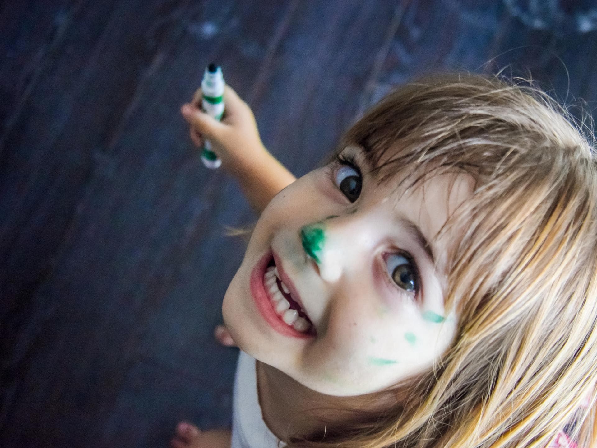 Lachendes Mädchen mit Stift in der Hand.