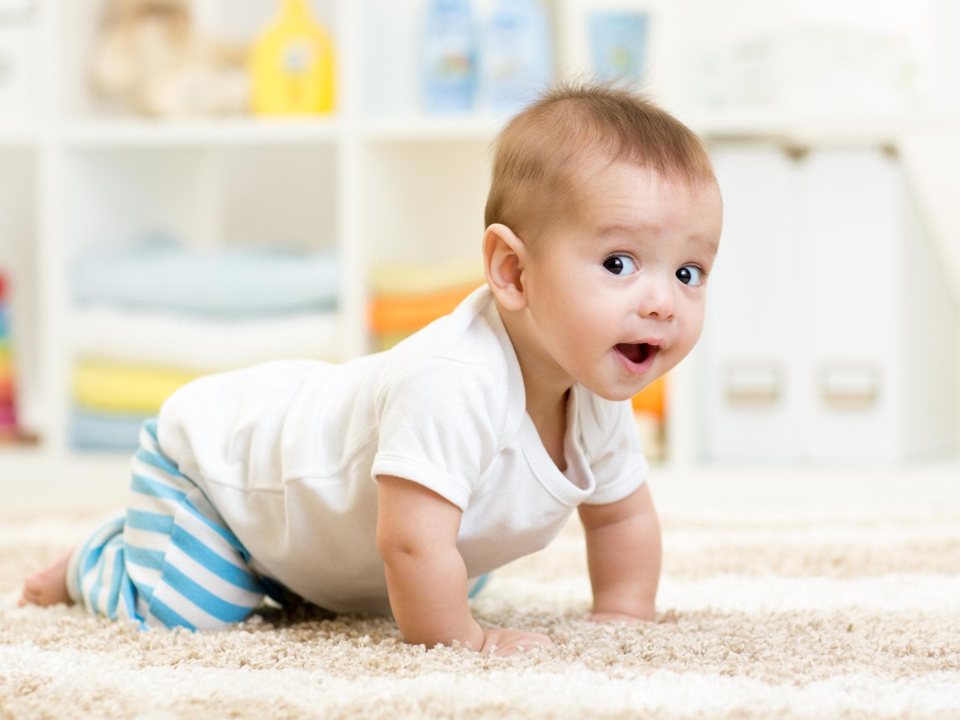 Baby krabbelt auf dem Teppich.