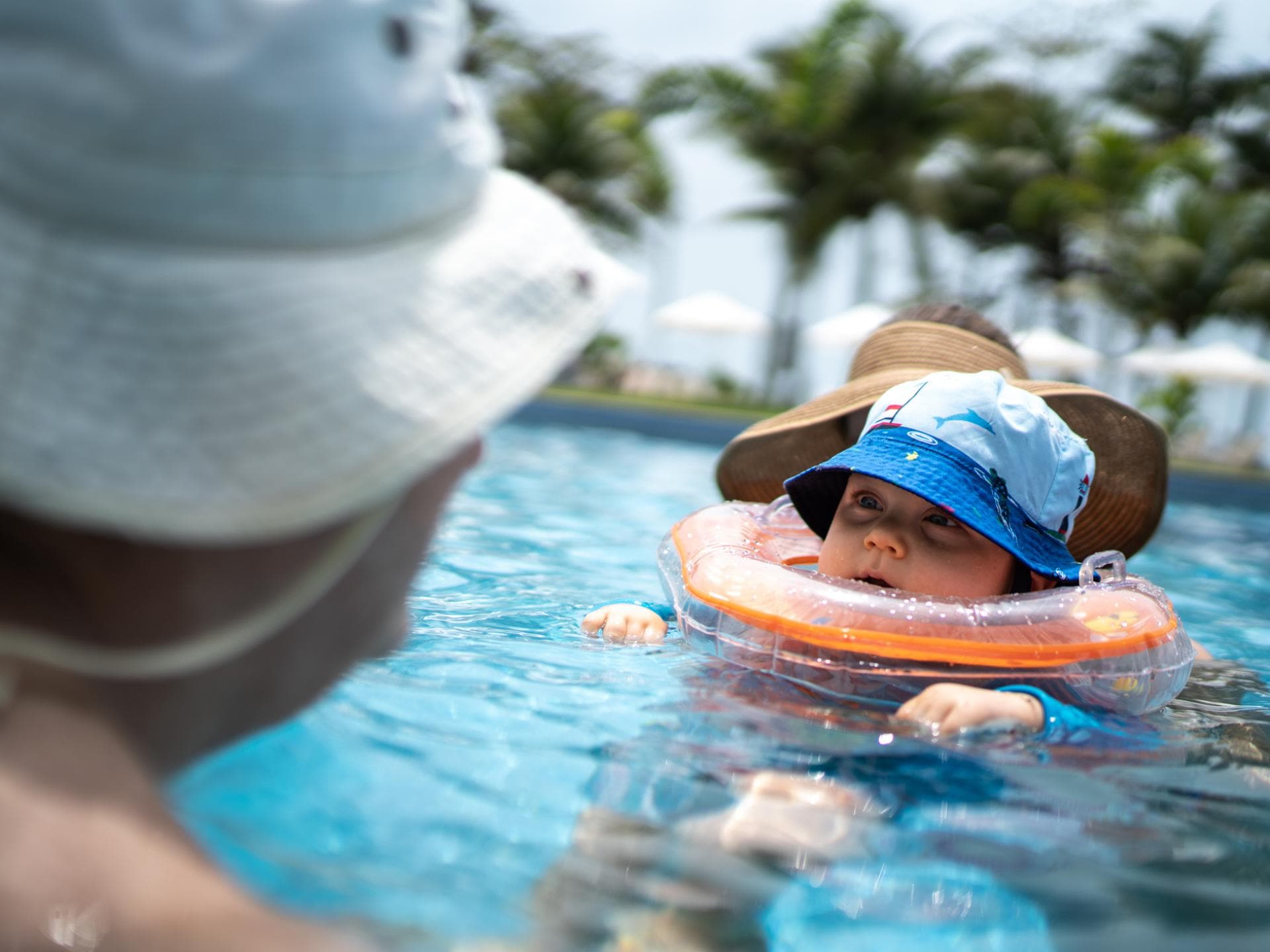 Baby mit Schwimmring um den Hals im Pool.