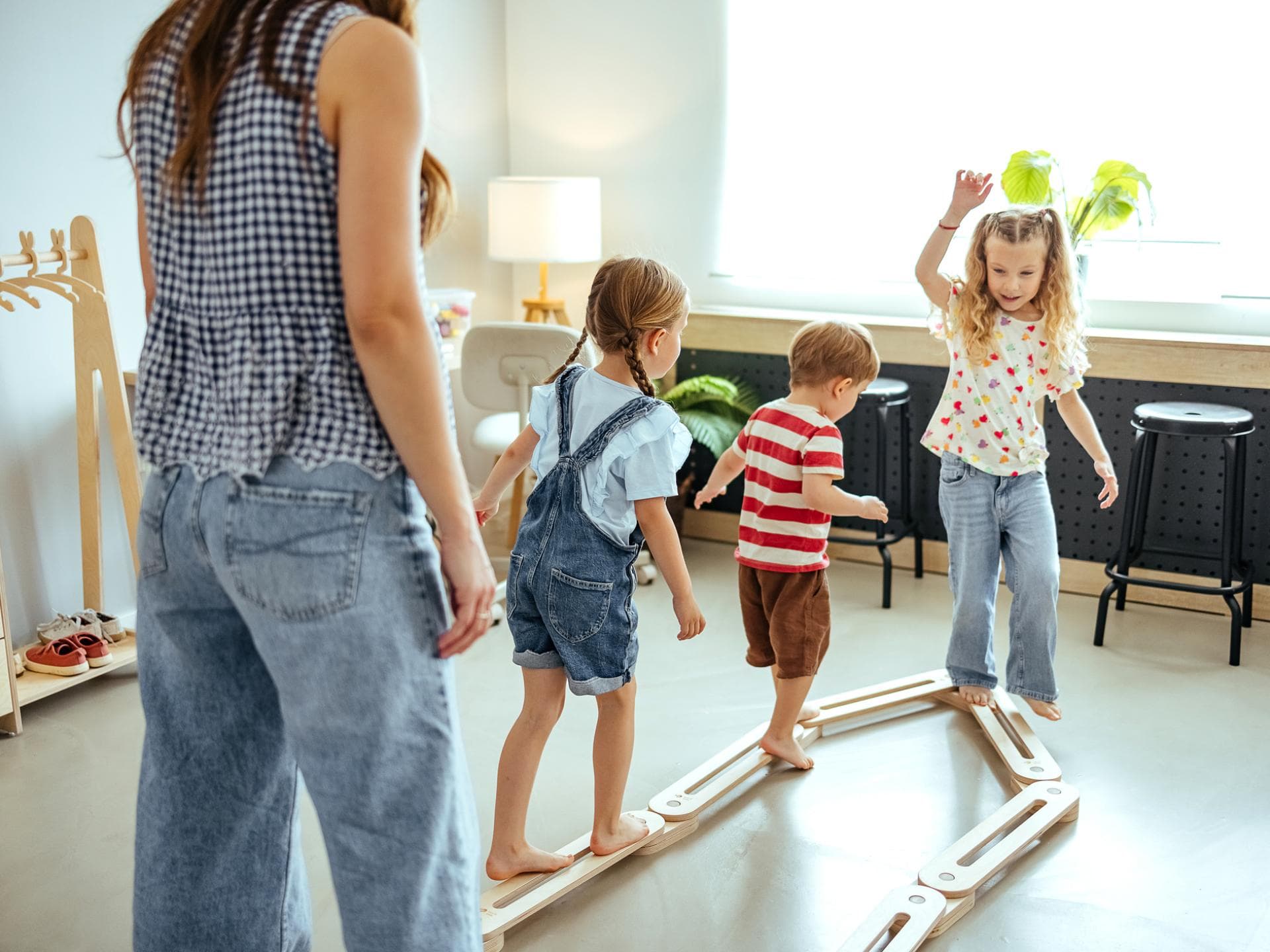 Drei Kinder spielen mit einer Frau.