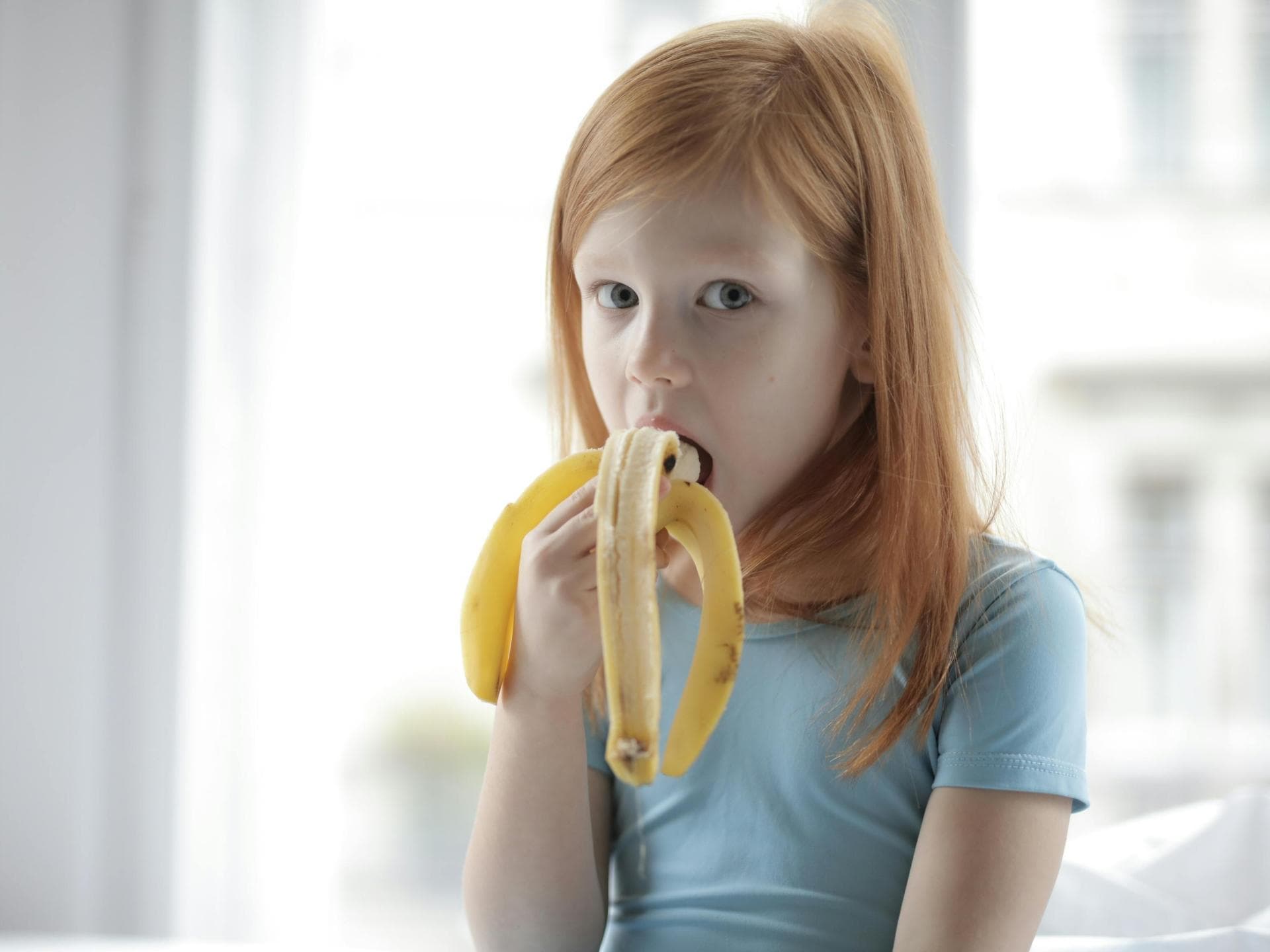 Kind isst Banane.