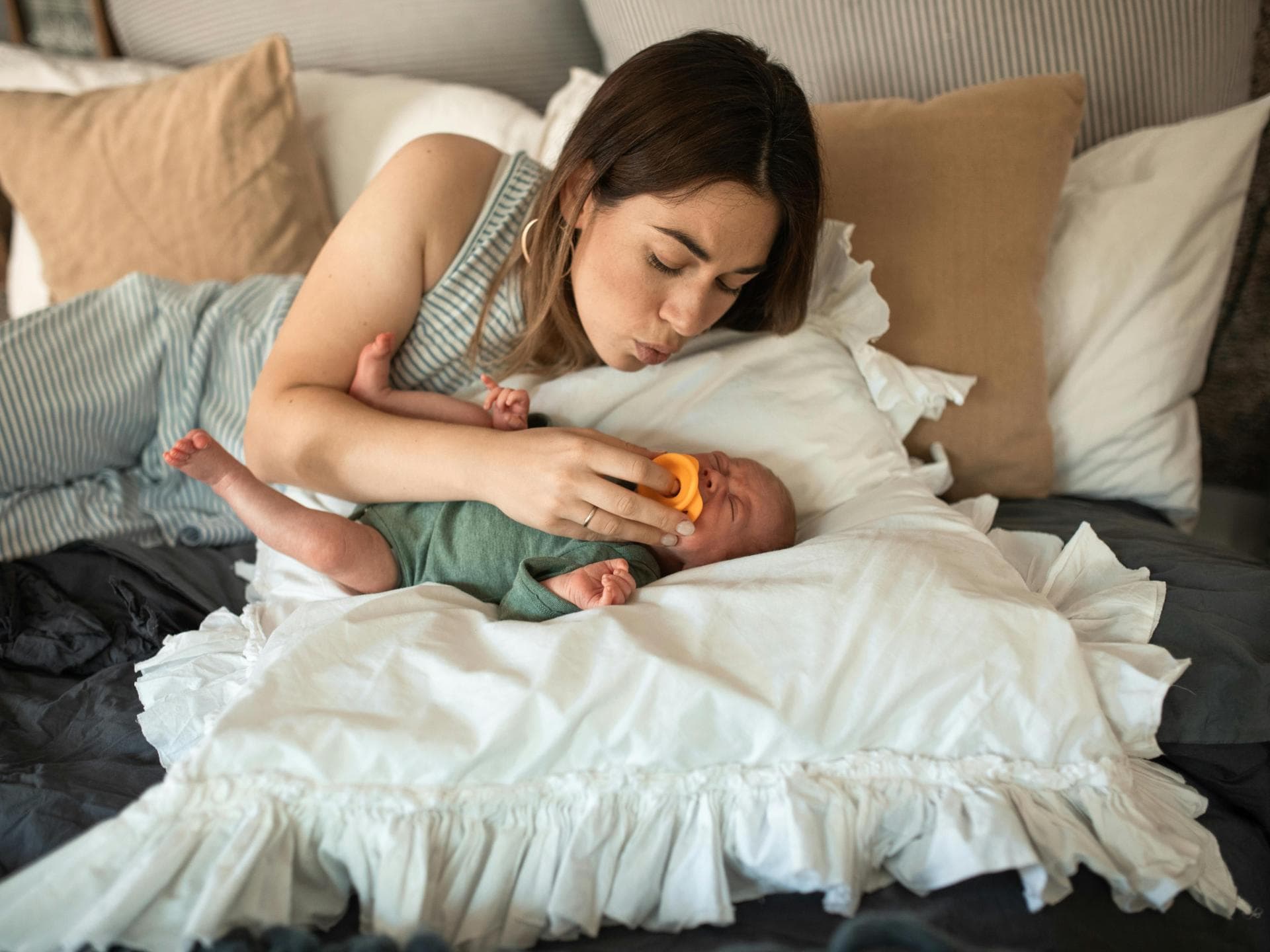 Nähe allein kann schon helfen, um ein Baby zu trösten. Eine Mutter tröstet ihr weinendes Baby.