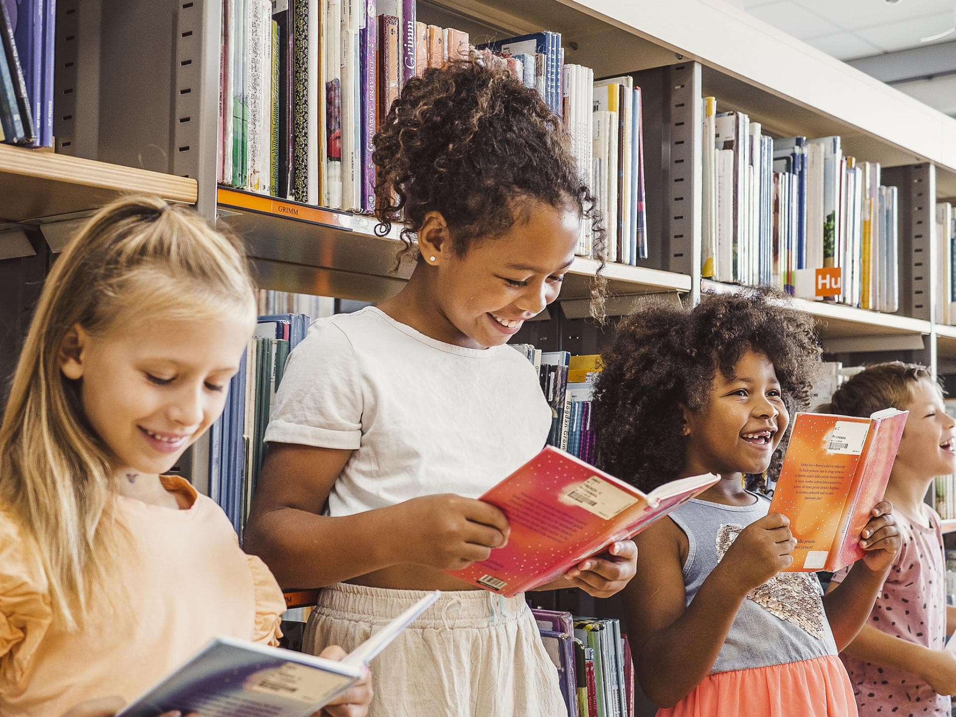 Kinder lesen in der Bibliothek.