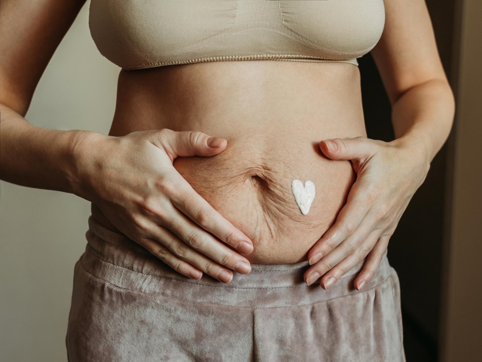 Frau mit faltigem Bauch nach der Geburt.
