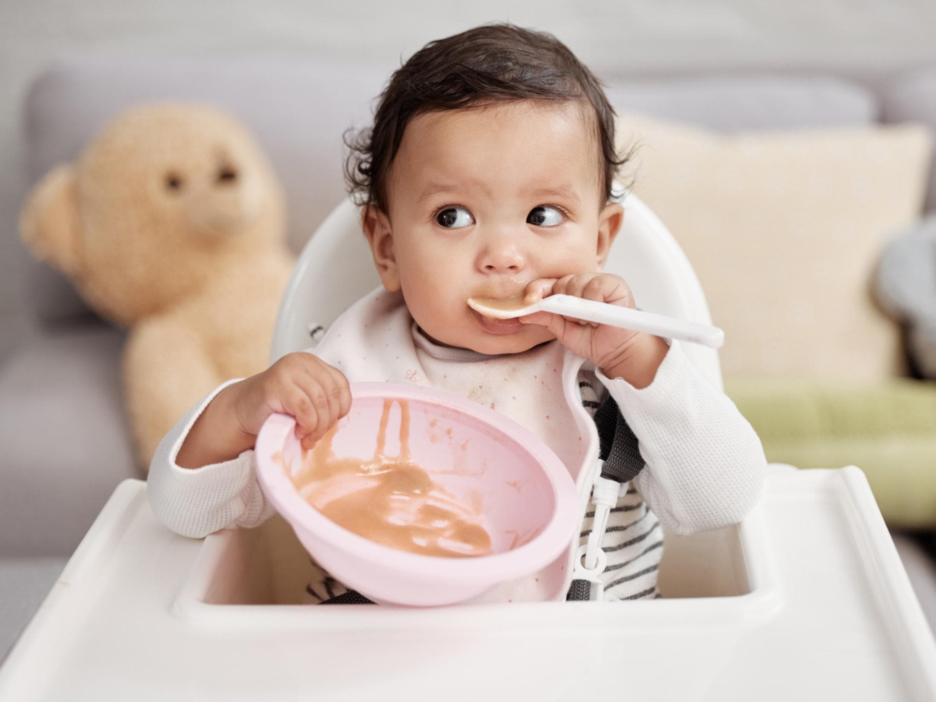 Obstbrei für Babys im Test. Baby löffelt Obstbrei.