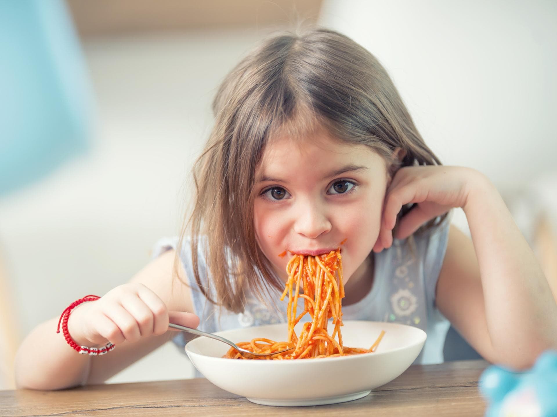 Abendessen schon vor 16 Uhr? Ja, gern! Ein Mädchen, das Spaghetti isst.