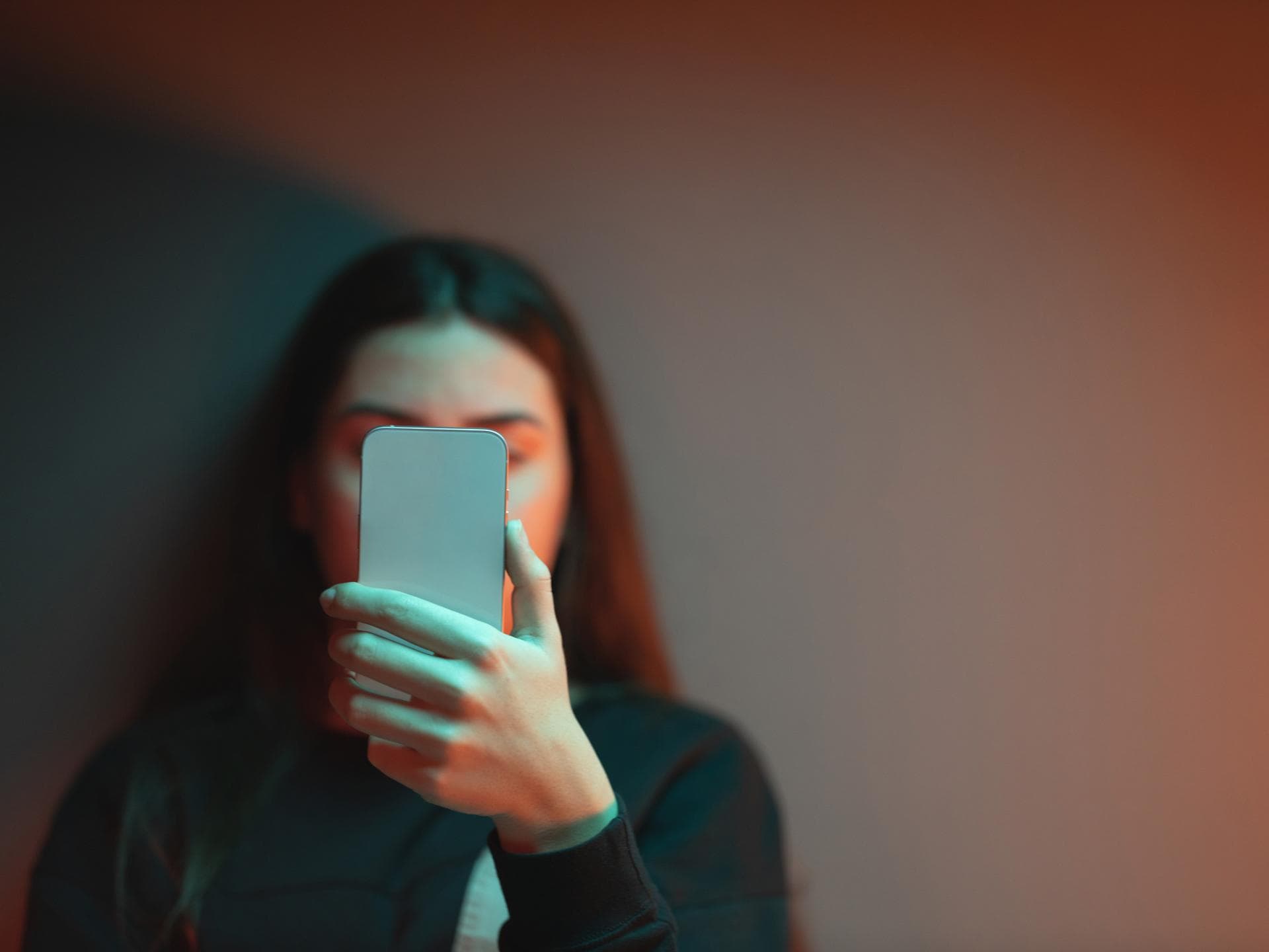 Die Dunkelziffer für Machtmissbrauch durch Lehrer ist hoch. Schülerin liest Nachricht auf ihrem Handy