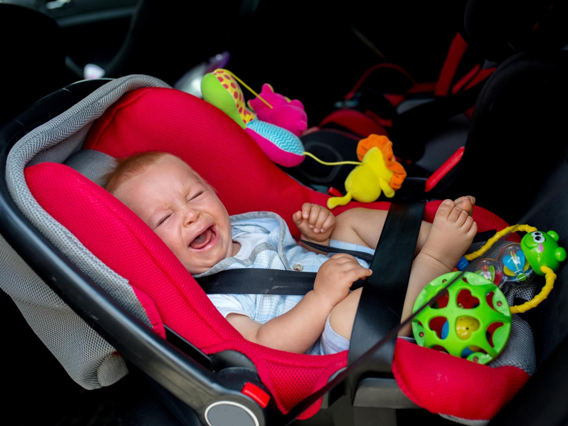 Baby schreit im Kindersitz.