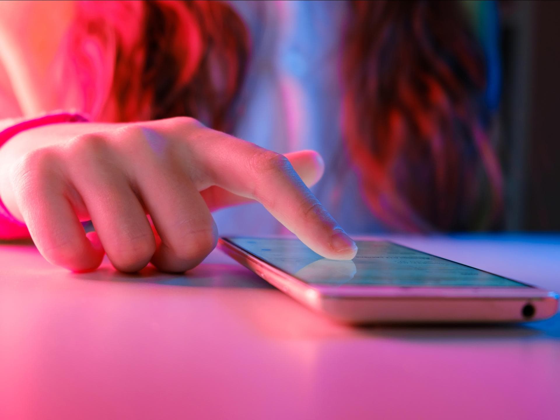 Zukünftig soll eine Altersbeschränkung gelten. Jugendliche wischt mit dem Finger übers Smartphone.