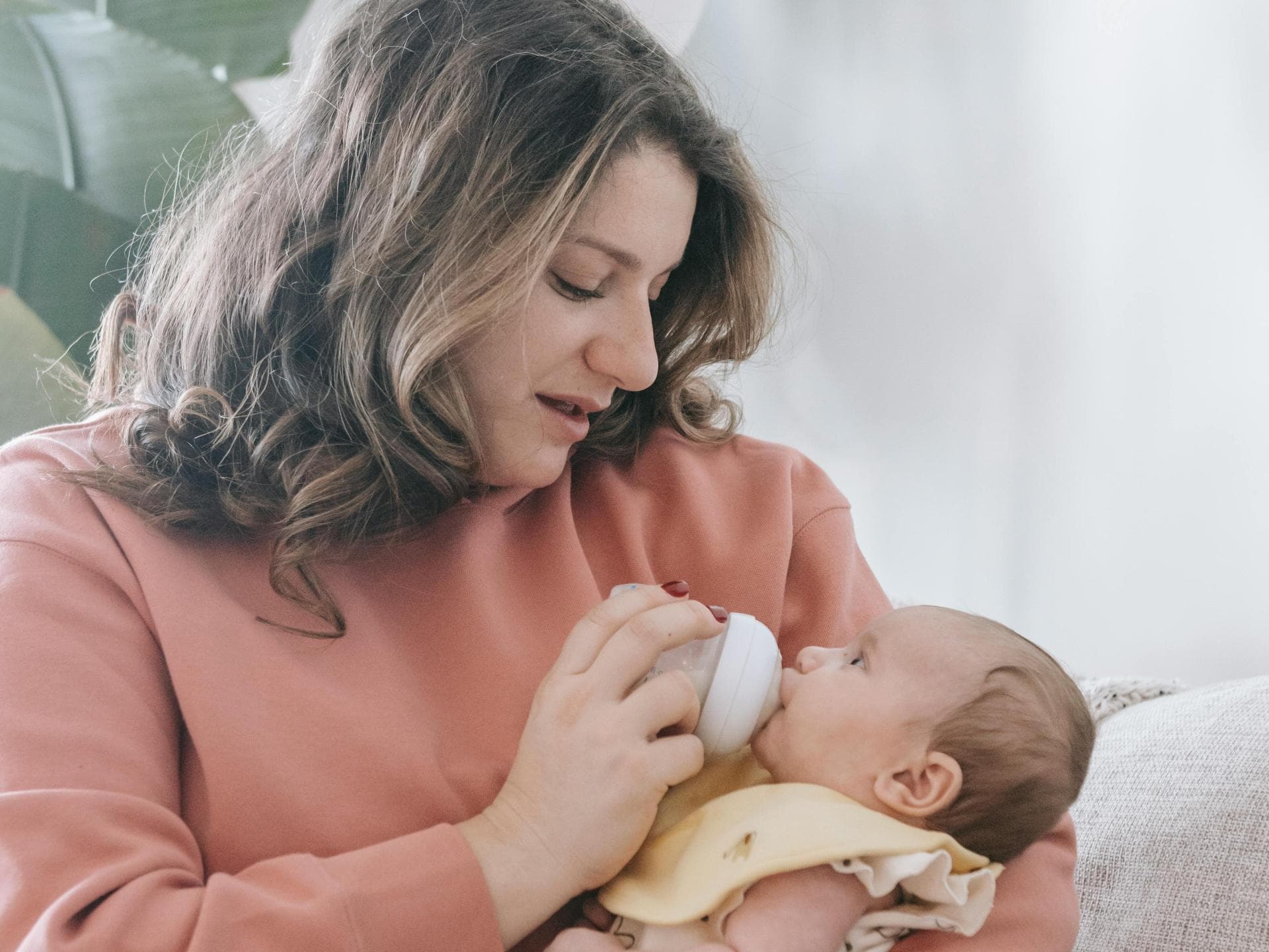 Das Fläschchen kann zu Übergewicht führen. Eine Mutter, die ihrem Baby das Fläschchen gibt.