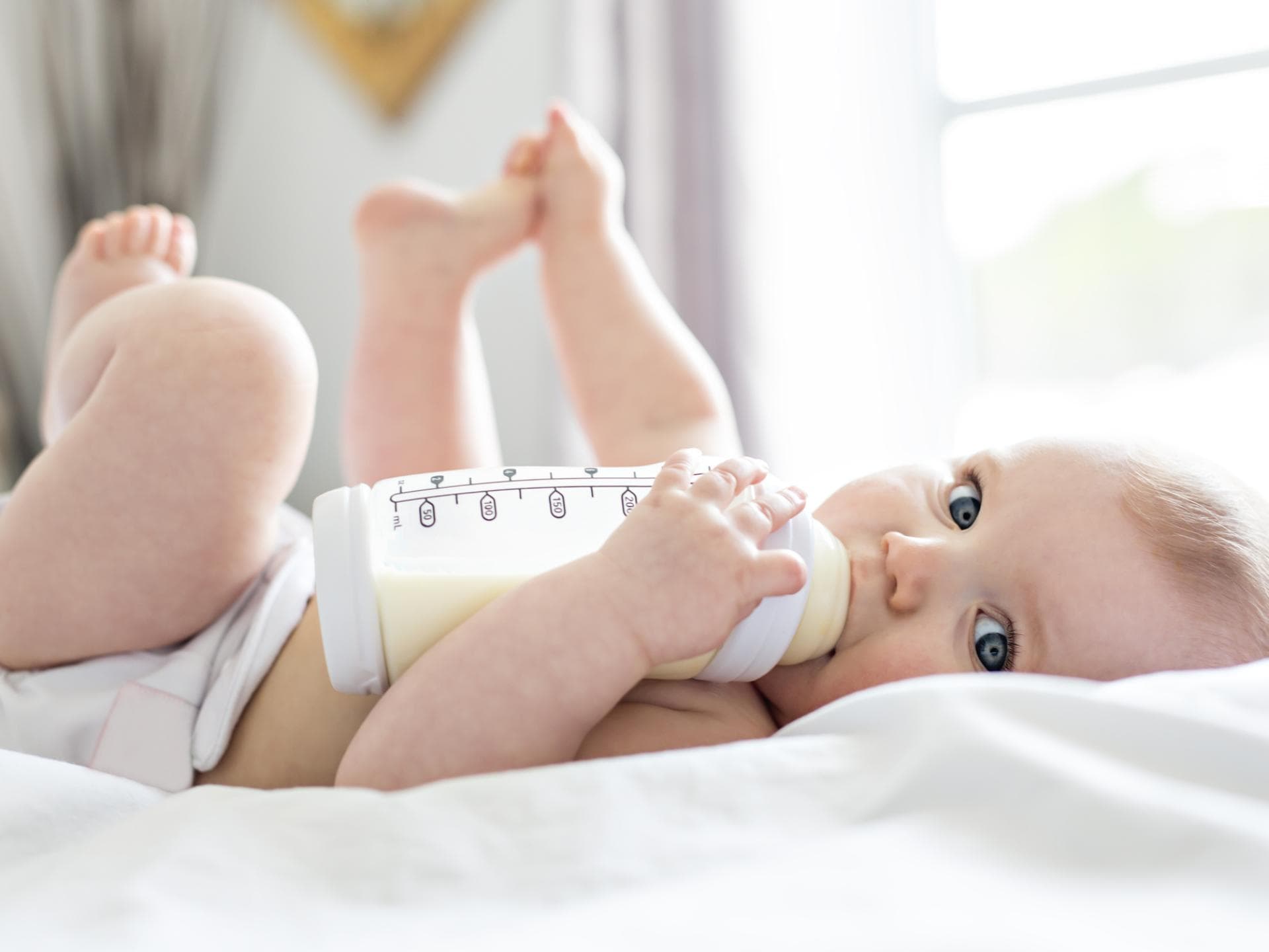 In vielen Pre-Nahrung-Produkten wurden Rückstände von Mineralöl gefunden. Baby trinkt aus Fläschchen.
