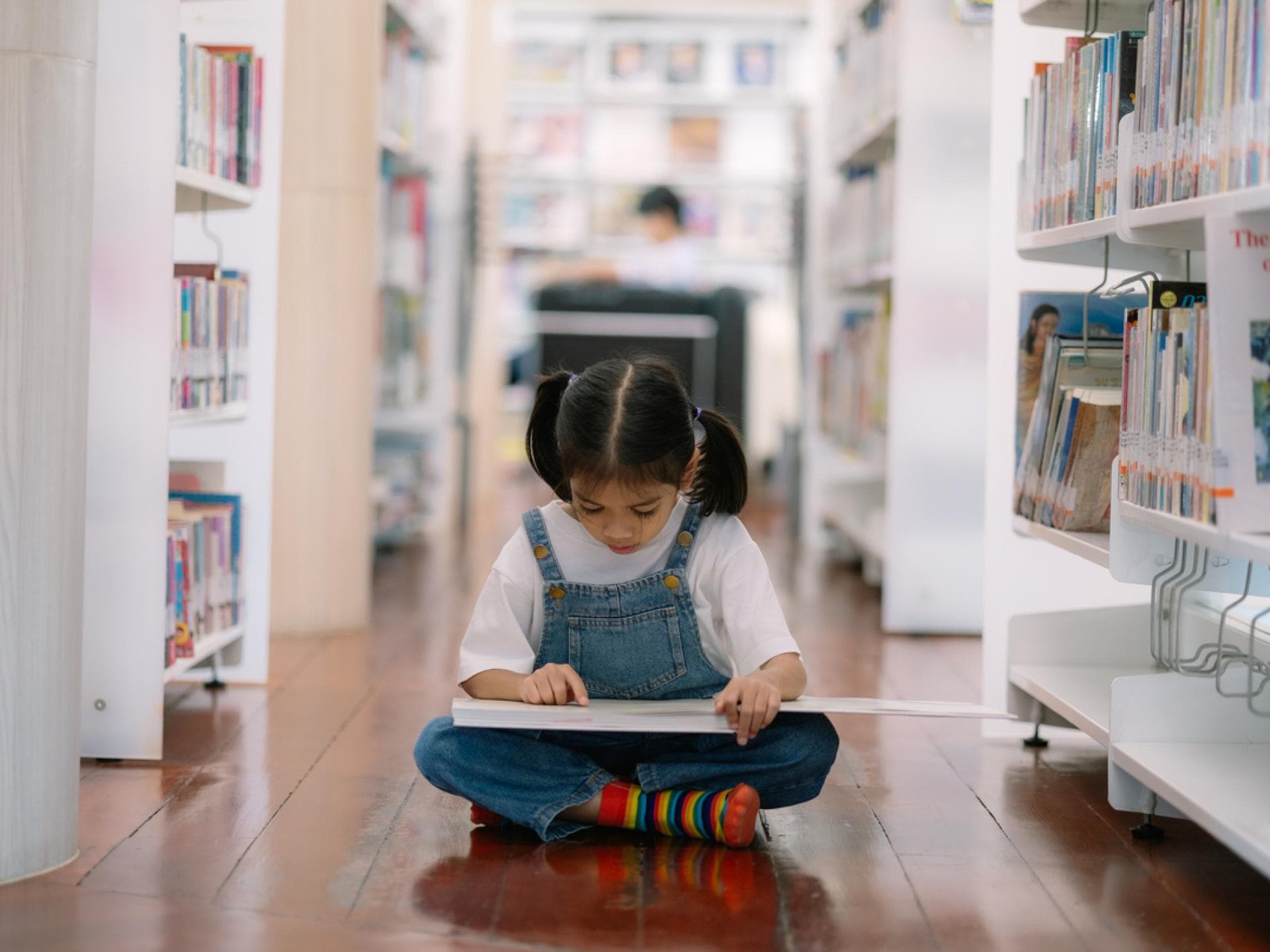 Kinderbuchhandlungen sind auf kleine Leser spezialisiert. Mädchen liest in Kinderbuchhandlung.